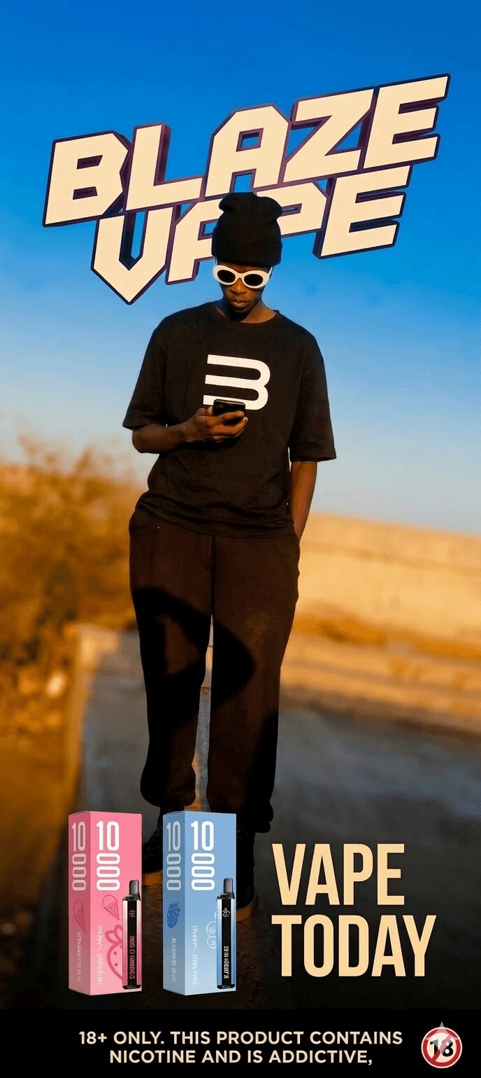 Person standing outdoors in black clothing and sunglasses, holding a phone, with a large sign reading 'BLAZE VAPE' in the background.