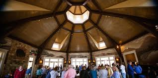 People gathered inside a circular room with a high, wooden, domed ceiling and large windows.