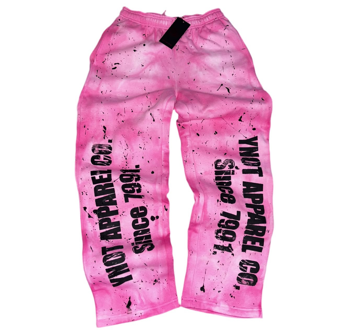 Pink pants with black text and paint splatter design, featuring slogans on each leg.