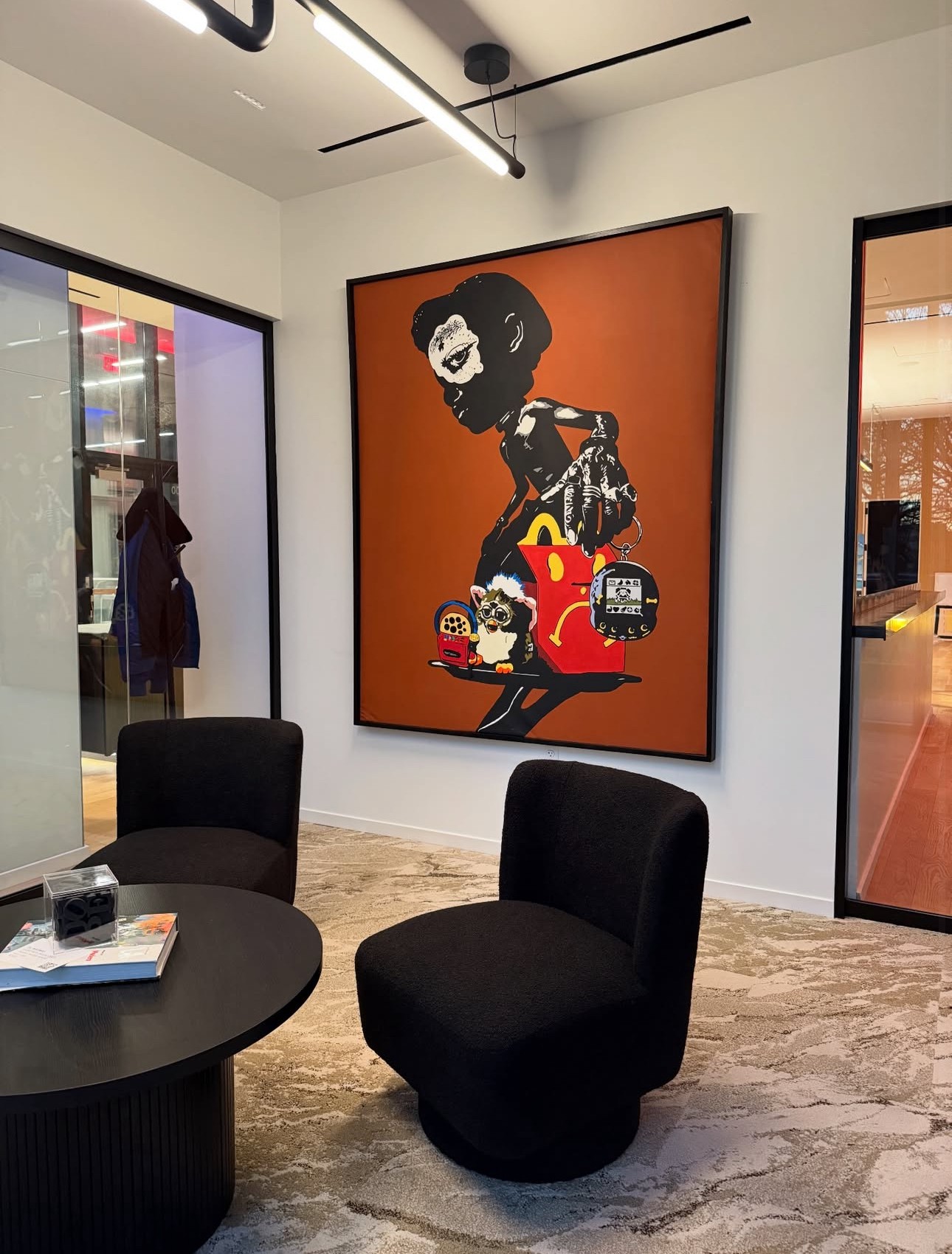 Artistic portrait of a woman with a large afro hairstyle, holding a red handbag, on an orange background.