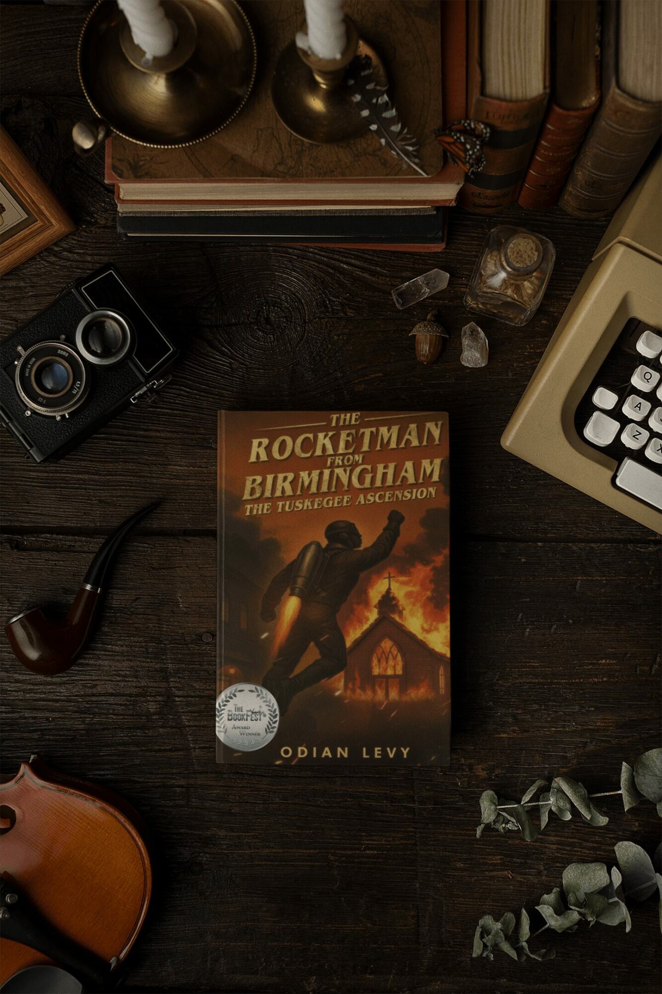 Book titled 'The Rocketman' on a dark wooden desk with a pipe, camera, and books nearby.