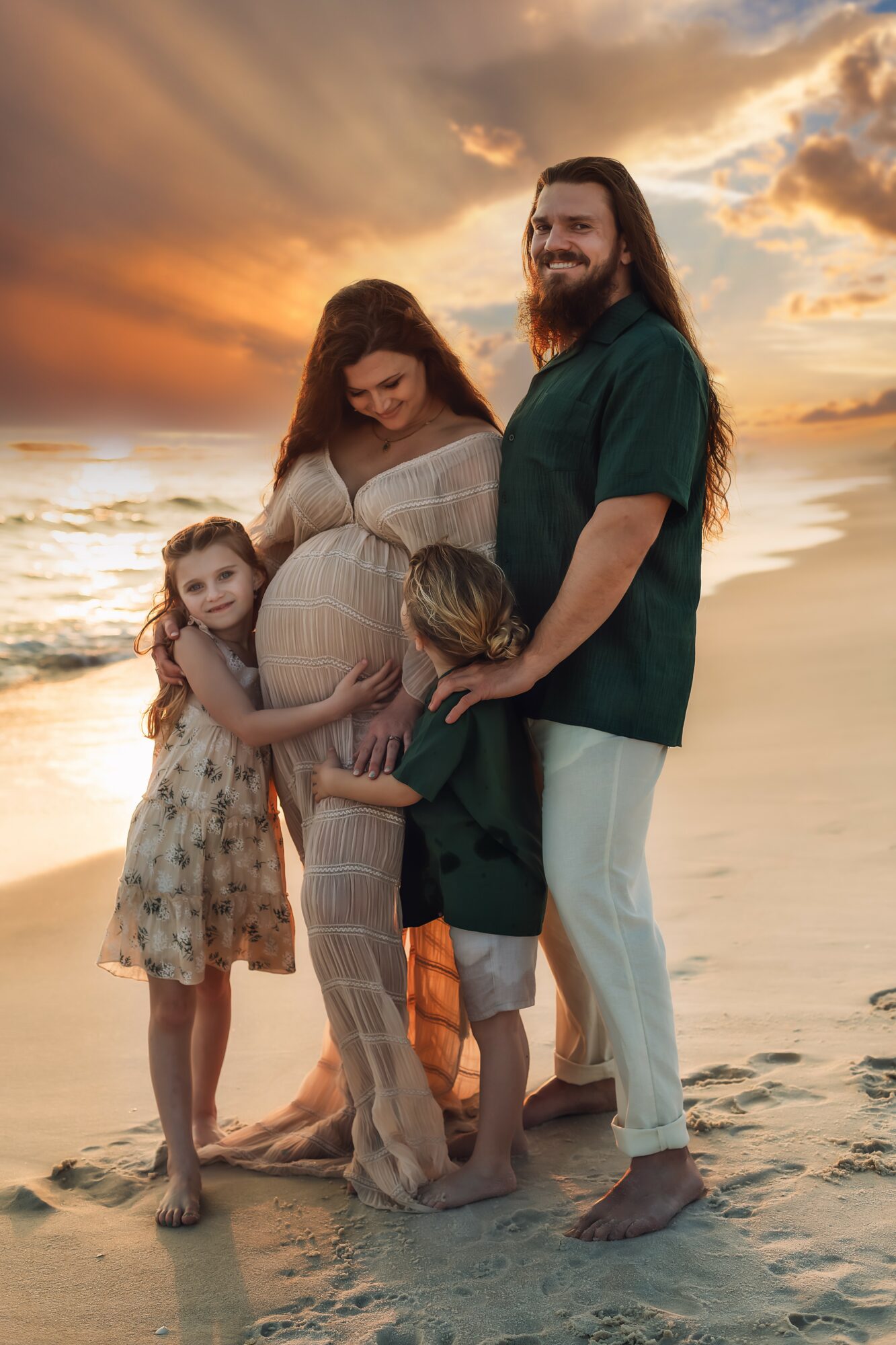 Family of five standing on beach at sunset, embracing and smiling, with ocean and sky in background.