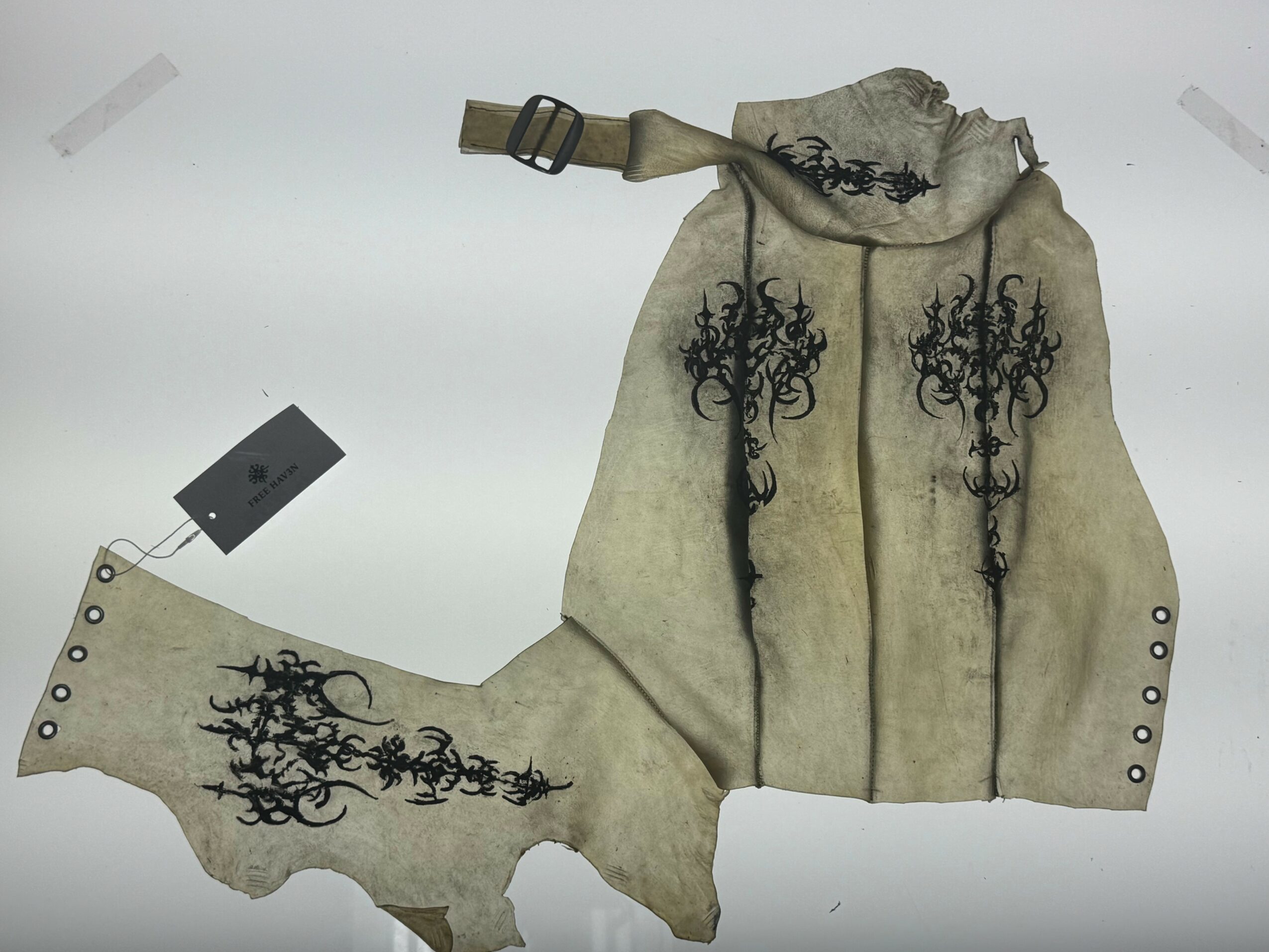 A torn, vintage map of the United States with black decorative patterns and a strap attached at the top.