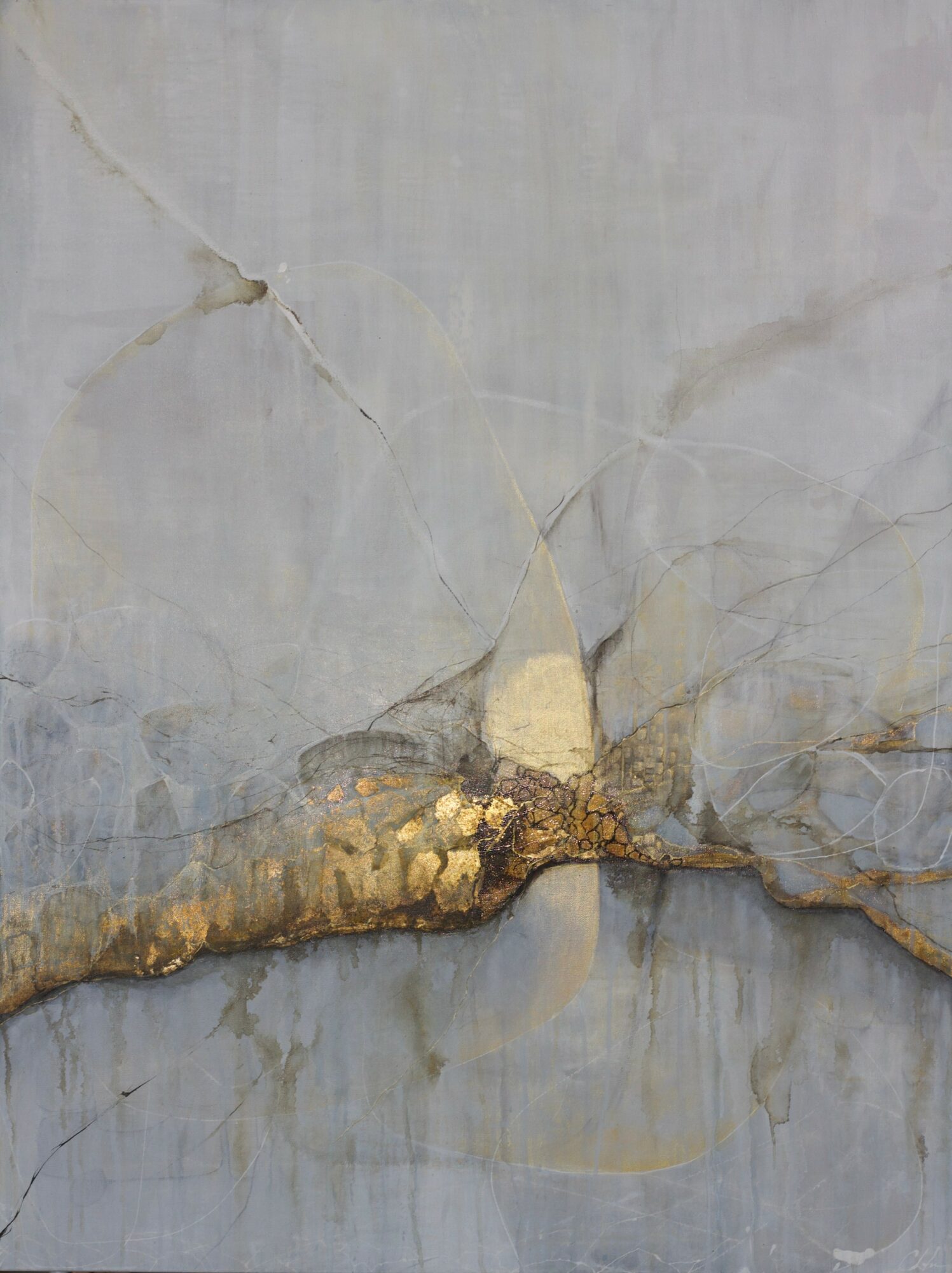 Close-up of a cracked, weathered surface with gold-colored details along a horizontal line.