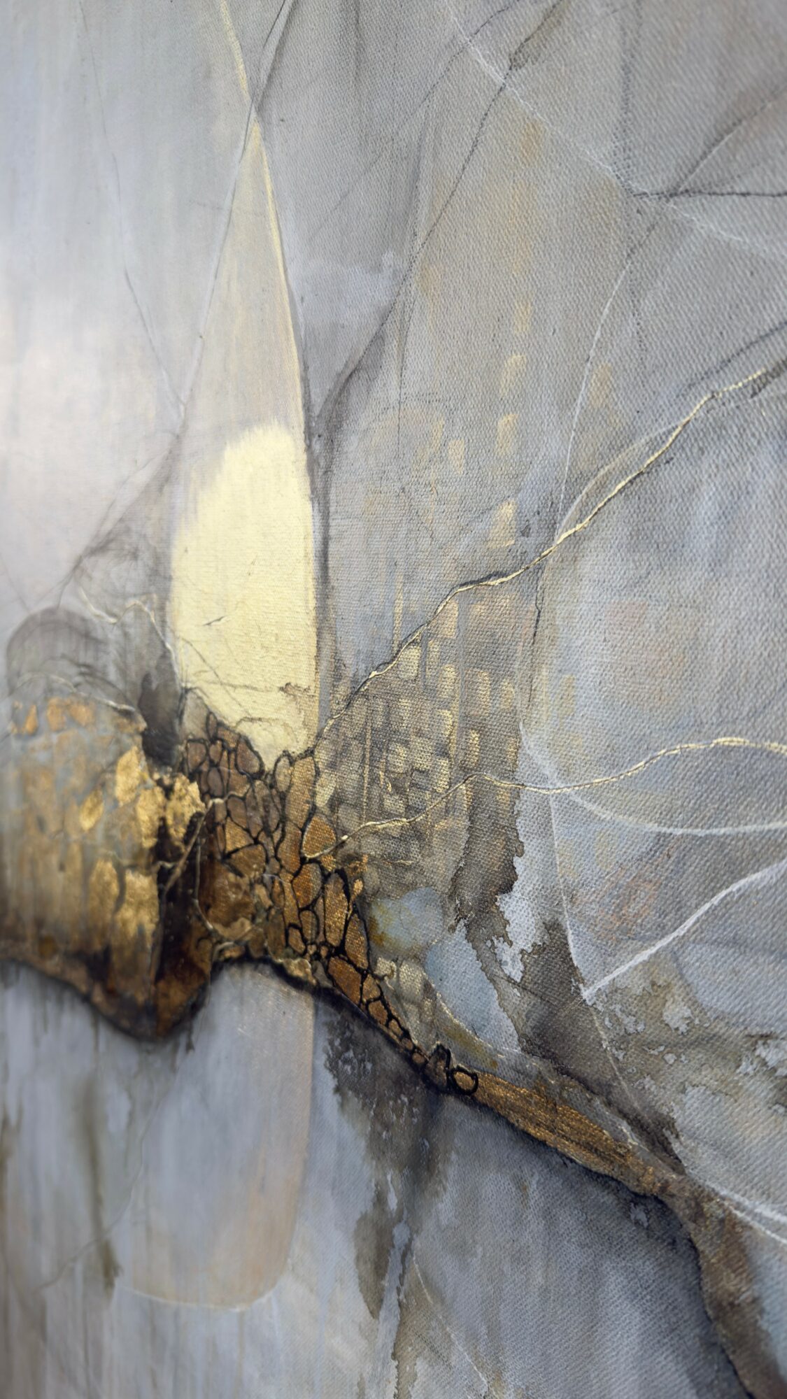 Close-up of a marble surface with gray, white, and gold veining and a crack running through it.