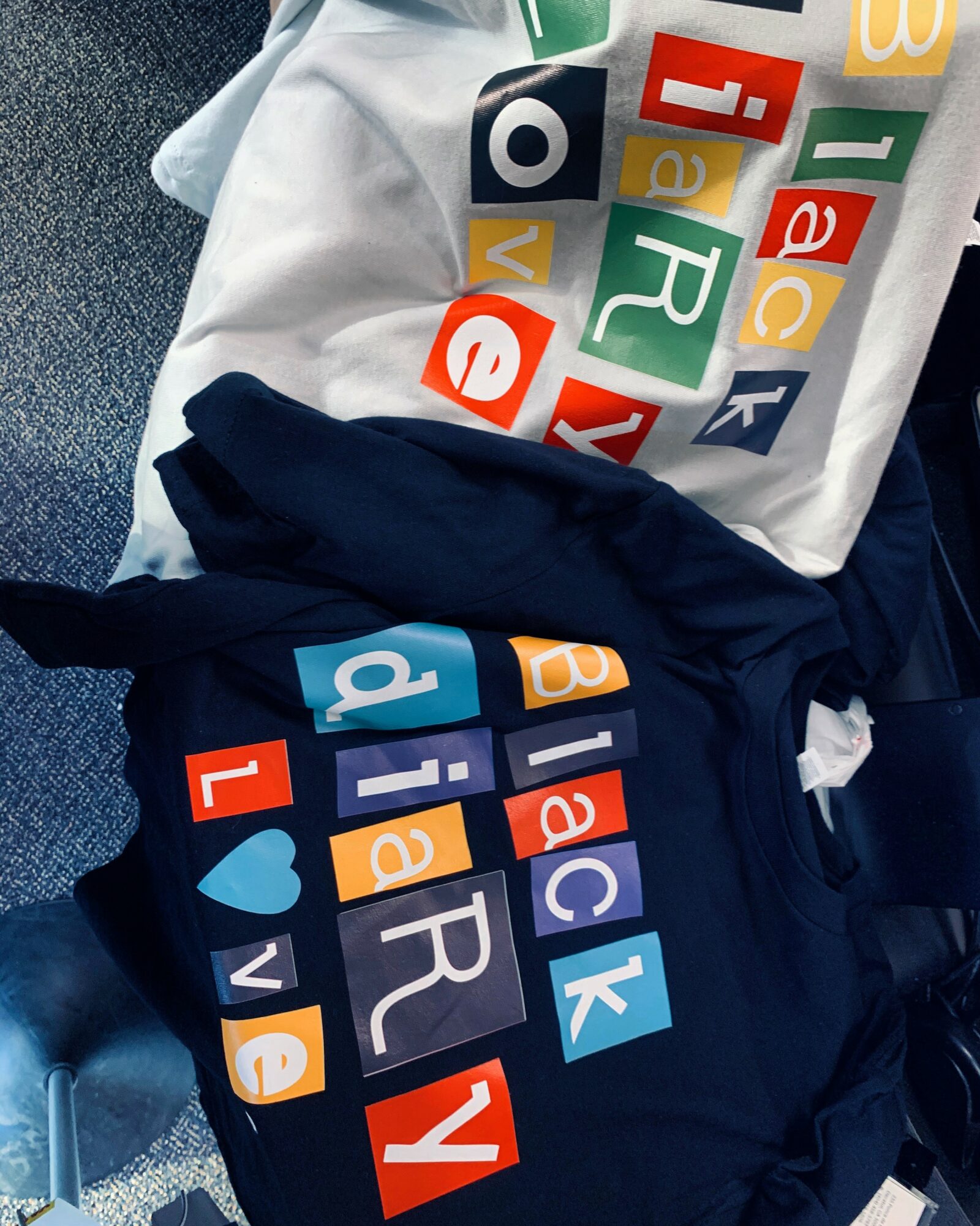Two bags with colorful alphabet blocks and letters, one white and one dark blue, on a surface.