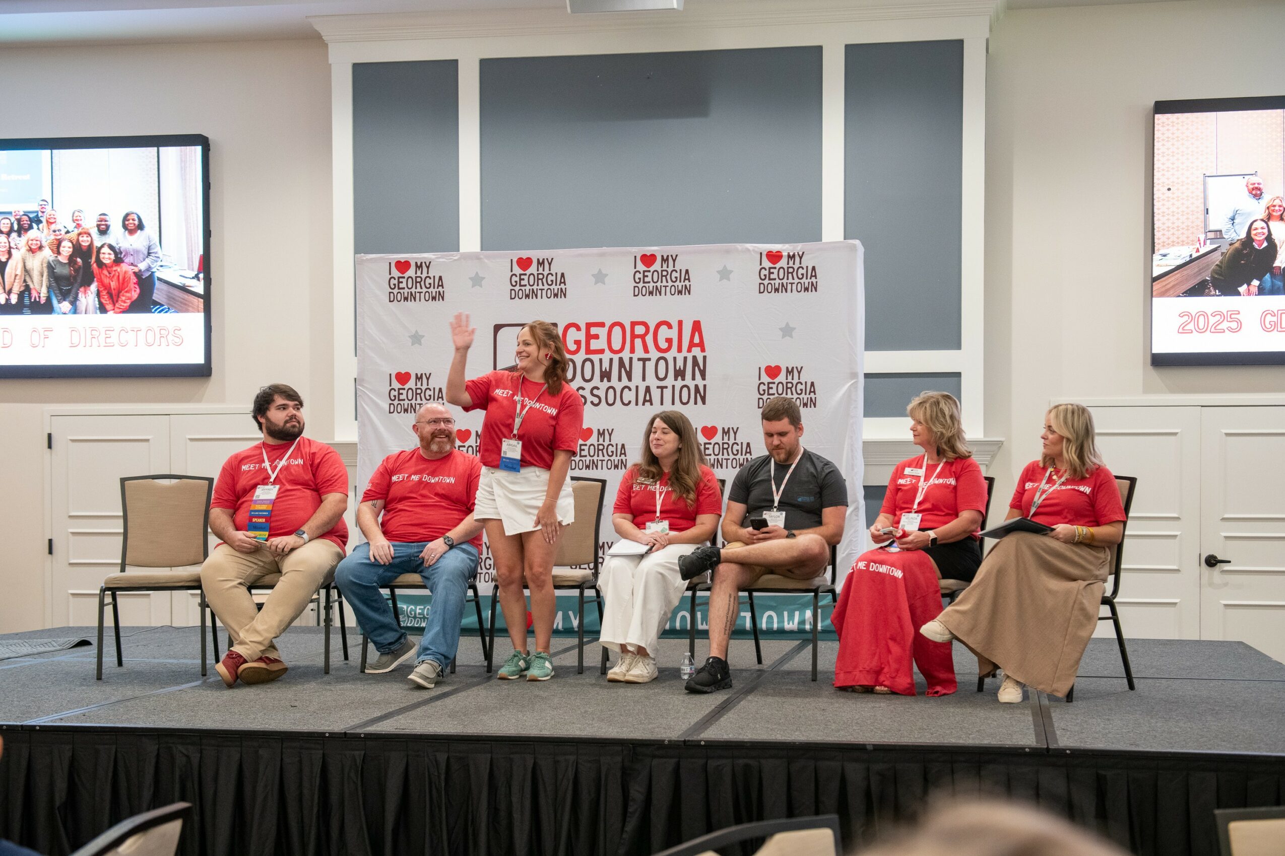 Six people sitting on a stage, participating in a panel discussion, with a Georgia Downtown Association banner behind them.