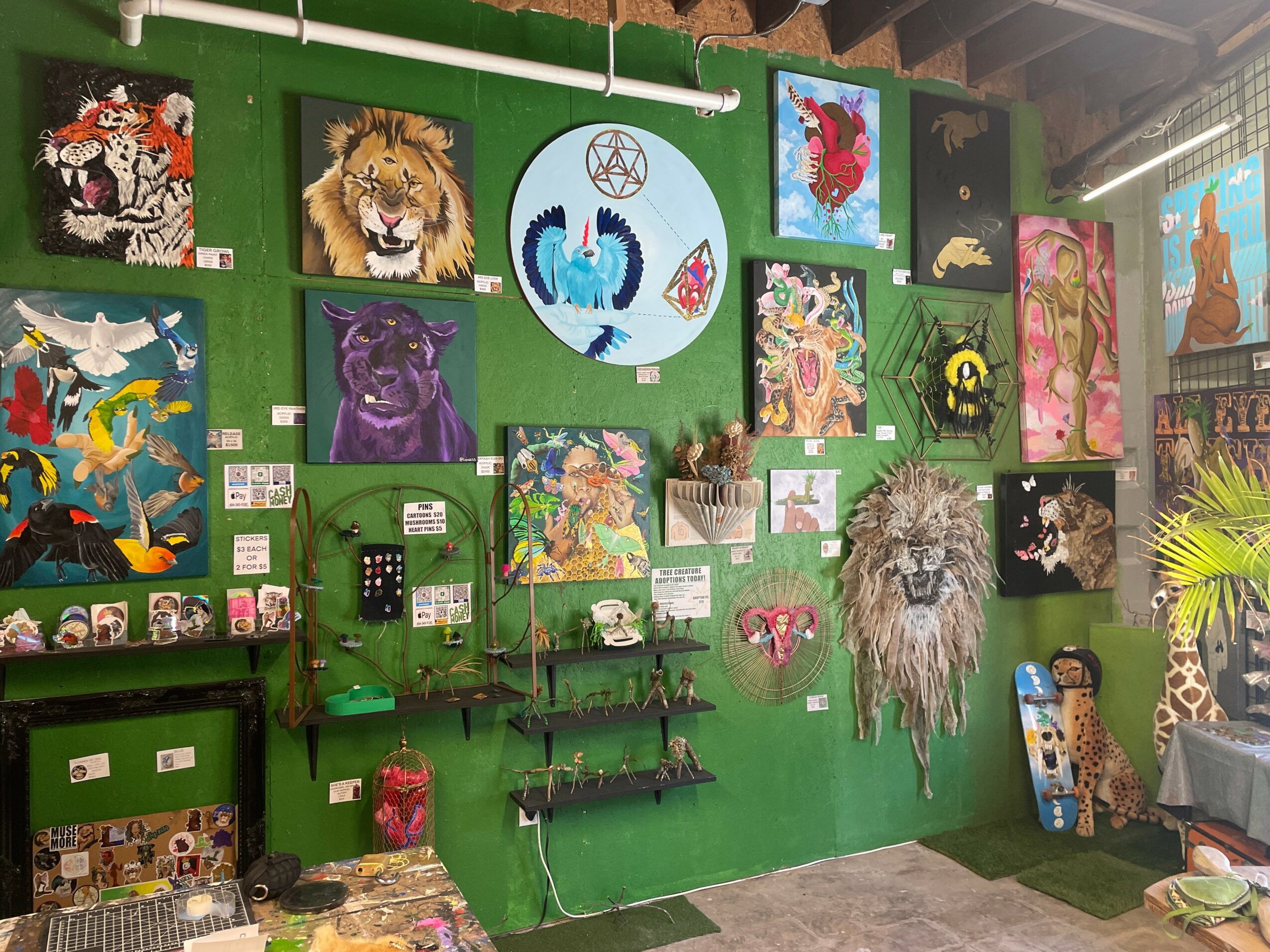 Green wall with various colorful paintings, shelves, and decorations including animals and abstract art.