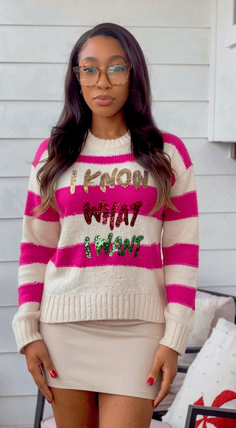 Woman with long dark hair wearing glasses, striped pink and white sweater, beige skirt, standing outdoors.
