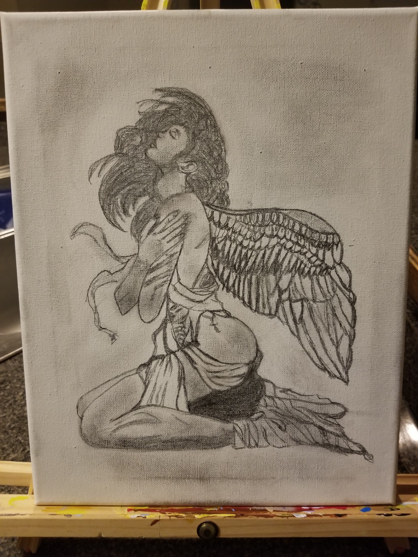 Sketch of a person with bird wings, sitting cross-legged, holding their knees, with long hair and detailed wings.