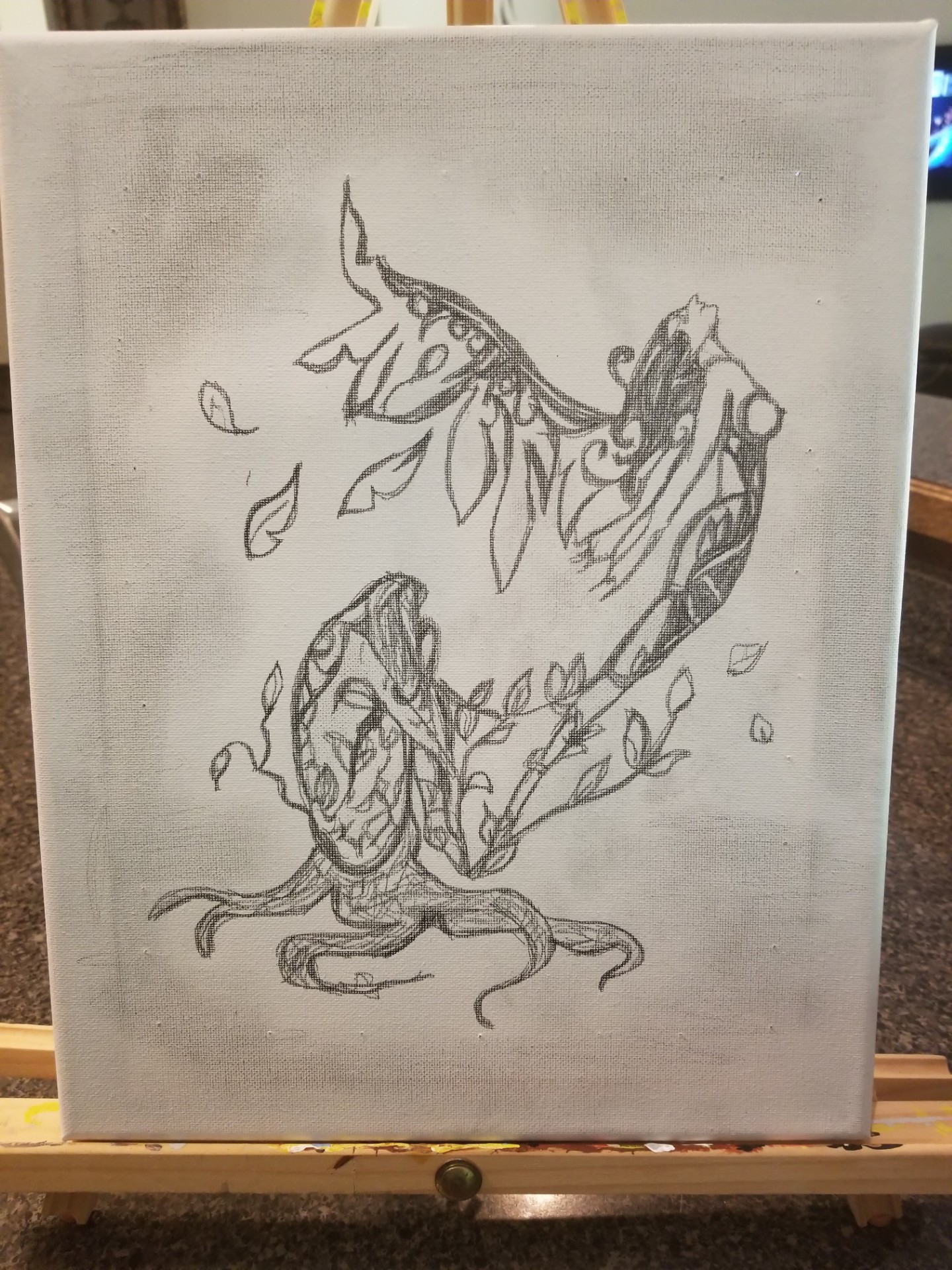 Sketch of a dragon with leaves and branches, with a face and wings, on a light background.