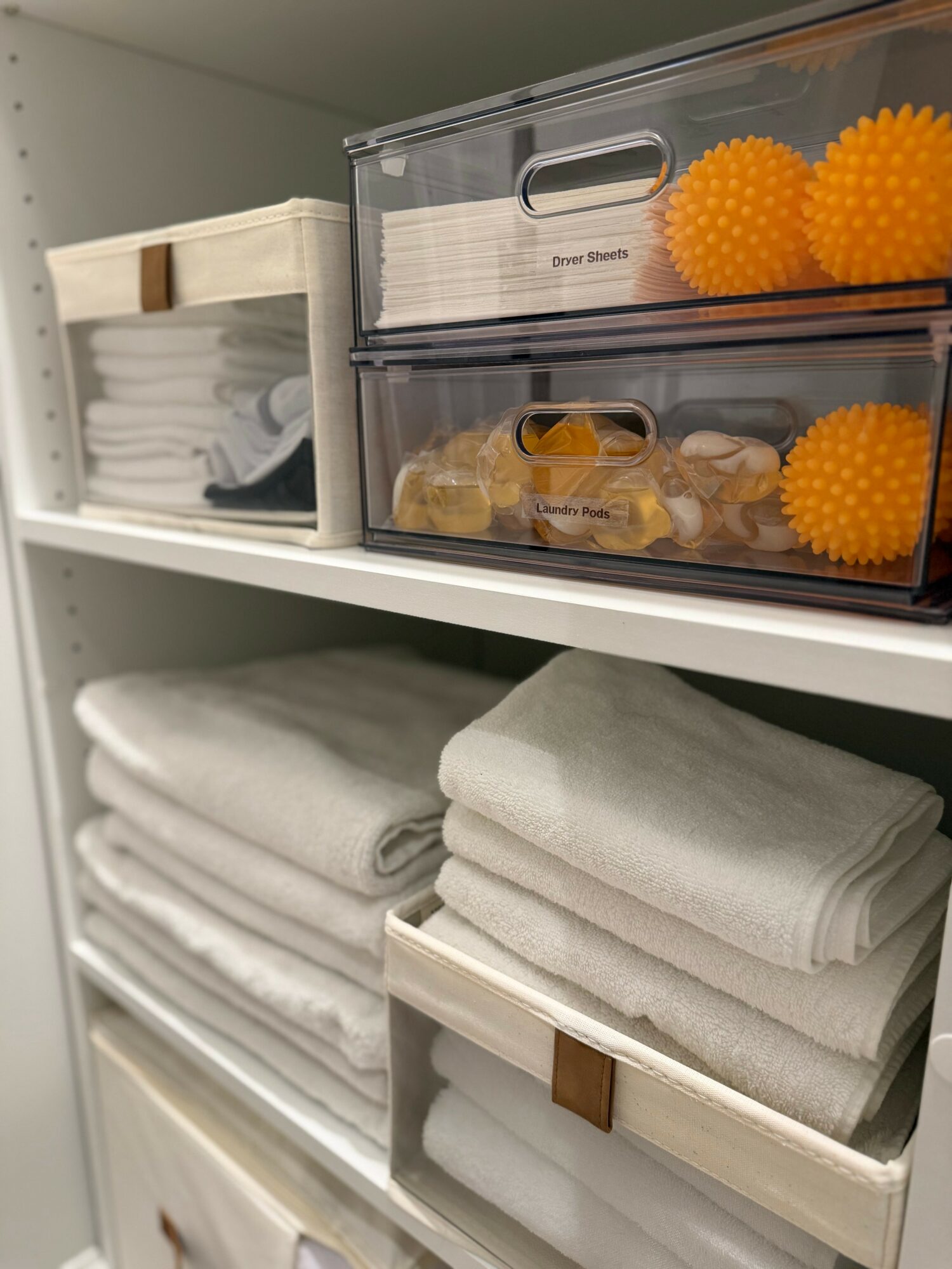 Shelves with neatly folded towels and storage boxes containing various items.
