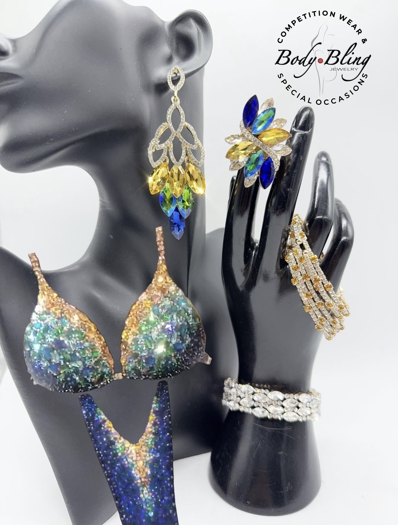 Display of colorful jewelry including earrings, rings, and a bikini top on a black mannequin hand and bust.