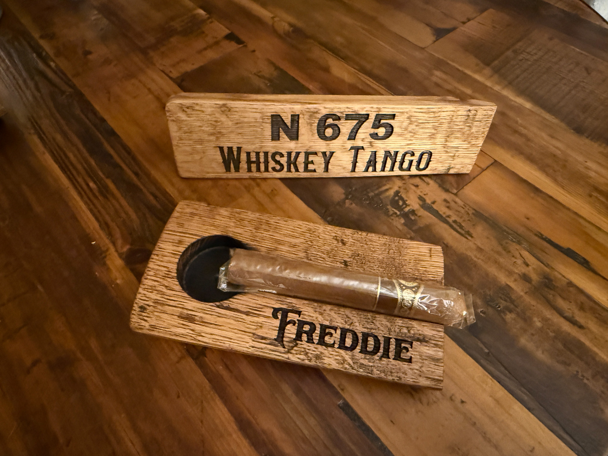 Wooden sign with text and a metal spoon resting on a matching wooden base.