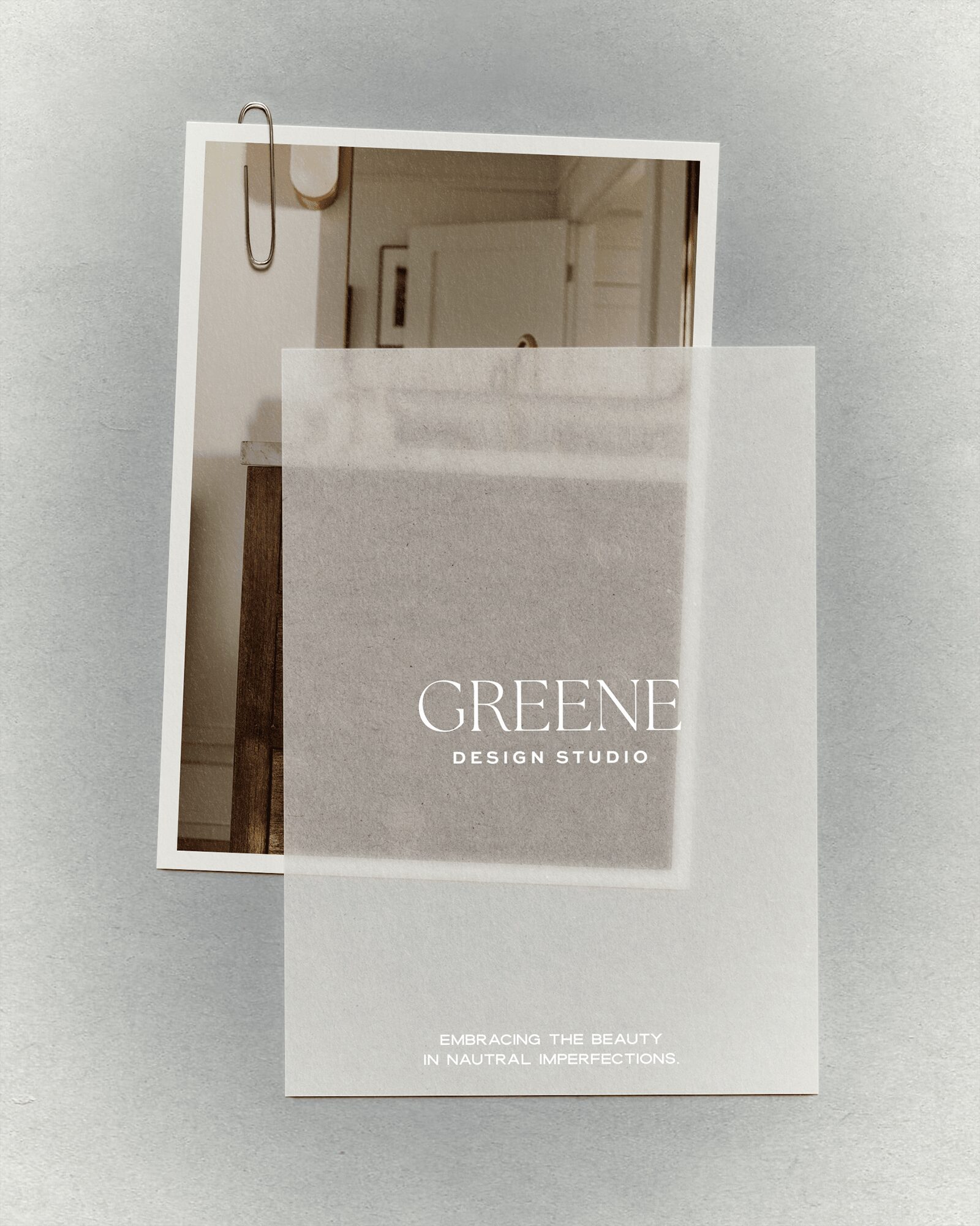 Mirror leaning against wall with a paper titled 'GRENE DESIGN STUDIO' in front of it, partially covering the mirror.