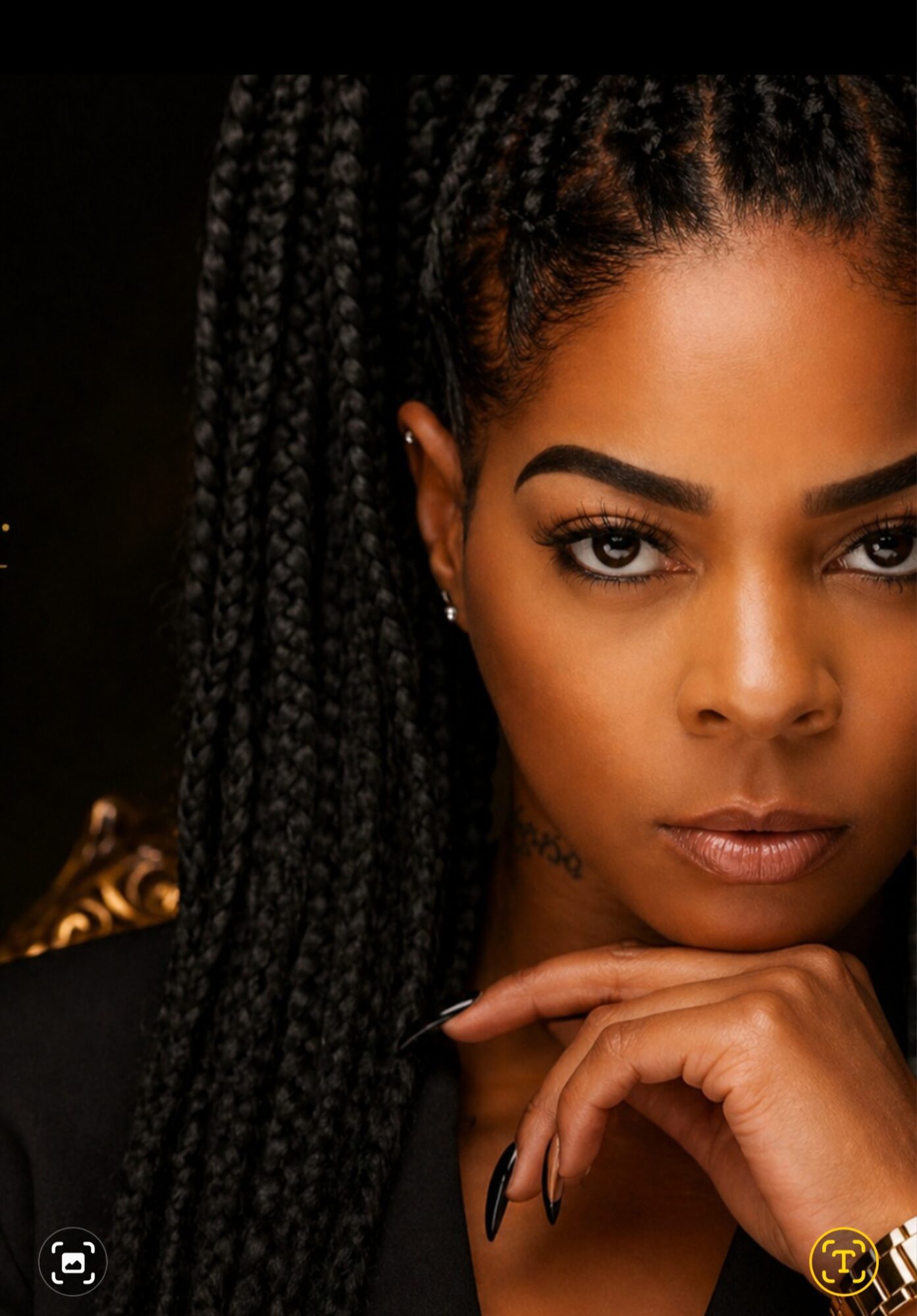 Close-up of a woman with braided hair, intense gaze, and hand near chin, dark background.