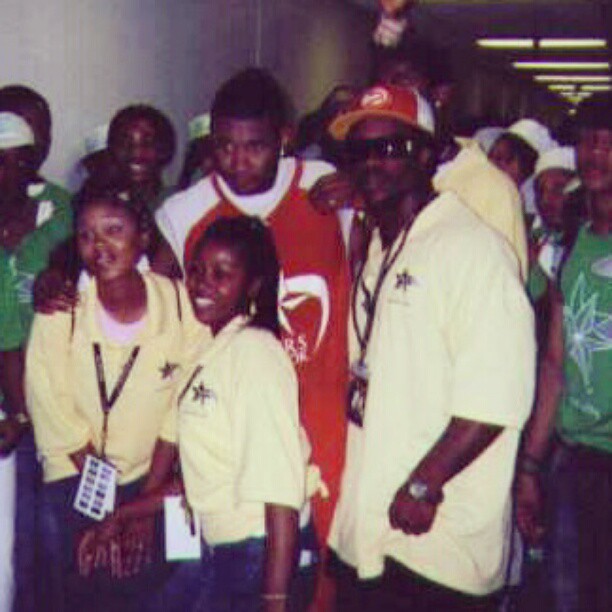Group of people standing together indoors, some smiling, wearing casual clothing and accessories.