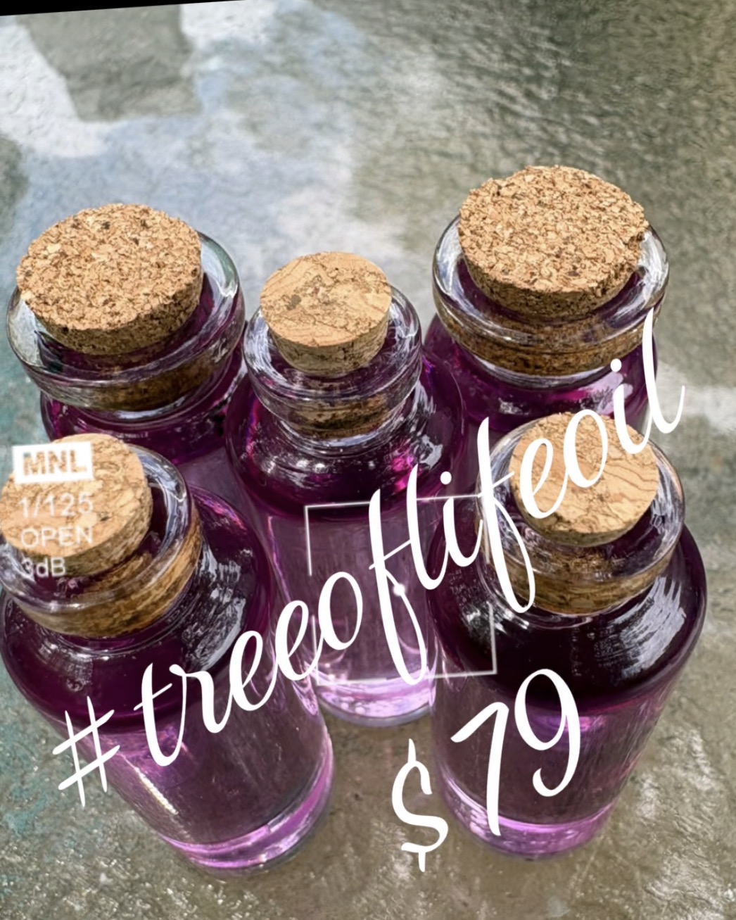 Six small glass bottles with cork stoppers filled with purple liquid, arranged on a surface outdoors.