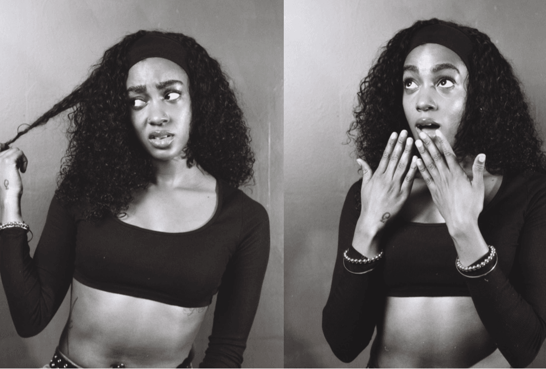 Two women with curly hair, wearing black crop tops, showing different facial expressions, one holding a strand of hair, the other covering her mouth.