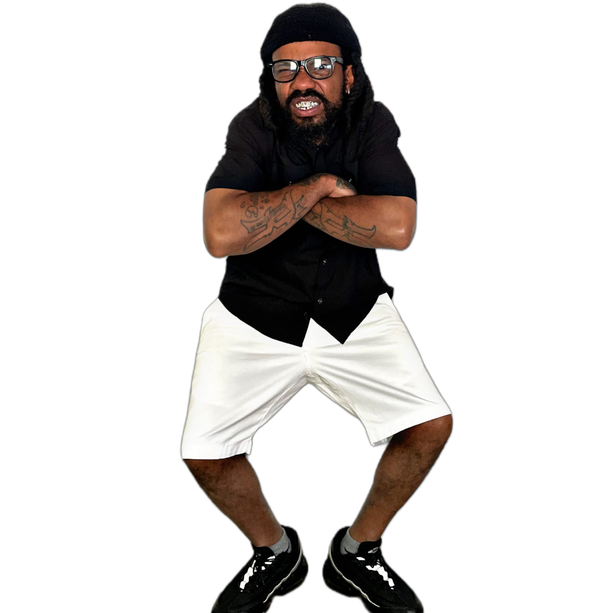 Man with long hair, glasses, black shirt, white shorts, black shoes, standing with arms crossed, smiling, against white background.