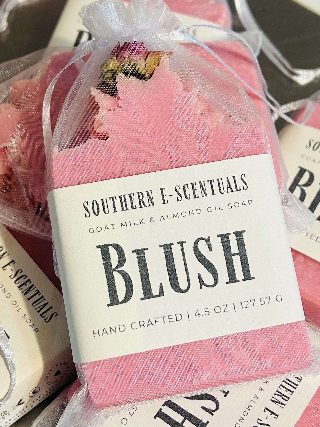Pink soap wrapped in sheer fabric with a label reading 'Southern E-Scentuals Blush' and soap details.