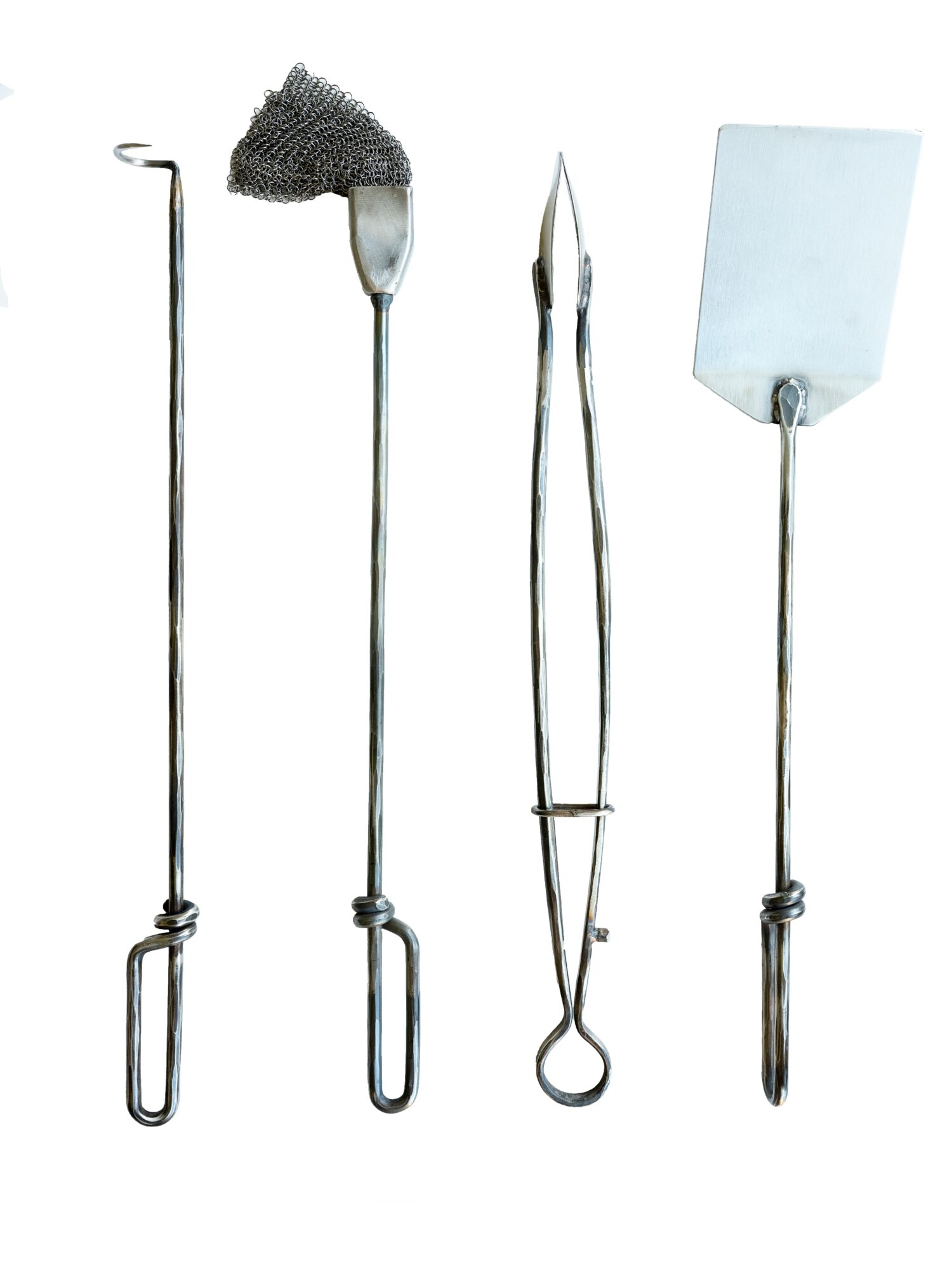 Four metal kitchen utensils: a long skewer, a slotted spoon, tongs, and a spatula, all upright against a white background.