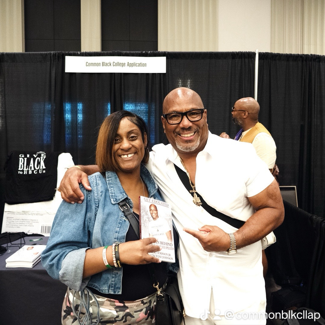 Two people smiling, one holding a card, at an event with a black curtain background and a sign reading 'Common Black College Applications'.