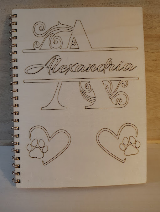 Notebook page with decorative line art, the name 'Alexandria' in cursive, and two hearts with paw prints inside.
