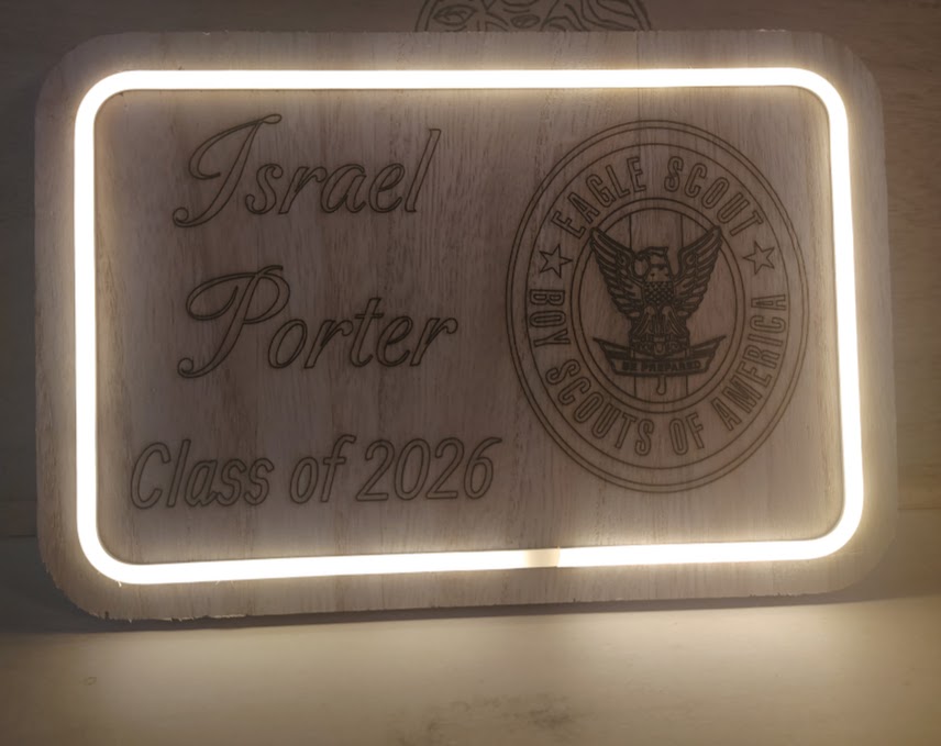 Illuminated sign with text and emblem, reading 'Israel Porter Class of 2026', with a circular emblem featuring an eagle and a shield.