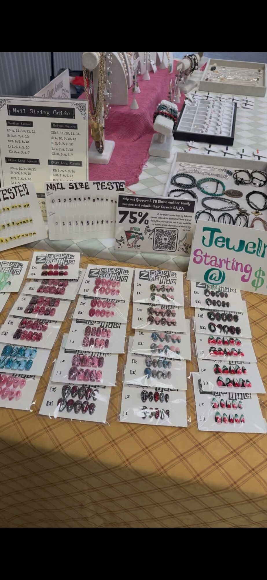 Display of various nail polish colors and nail art supplies on a table, with promotional flyers and price tags.