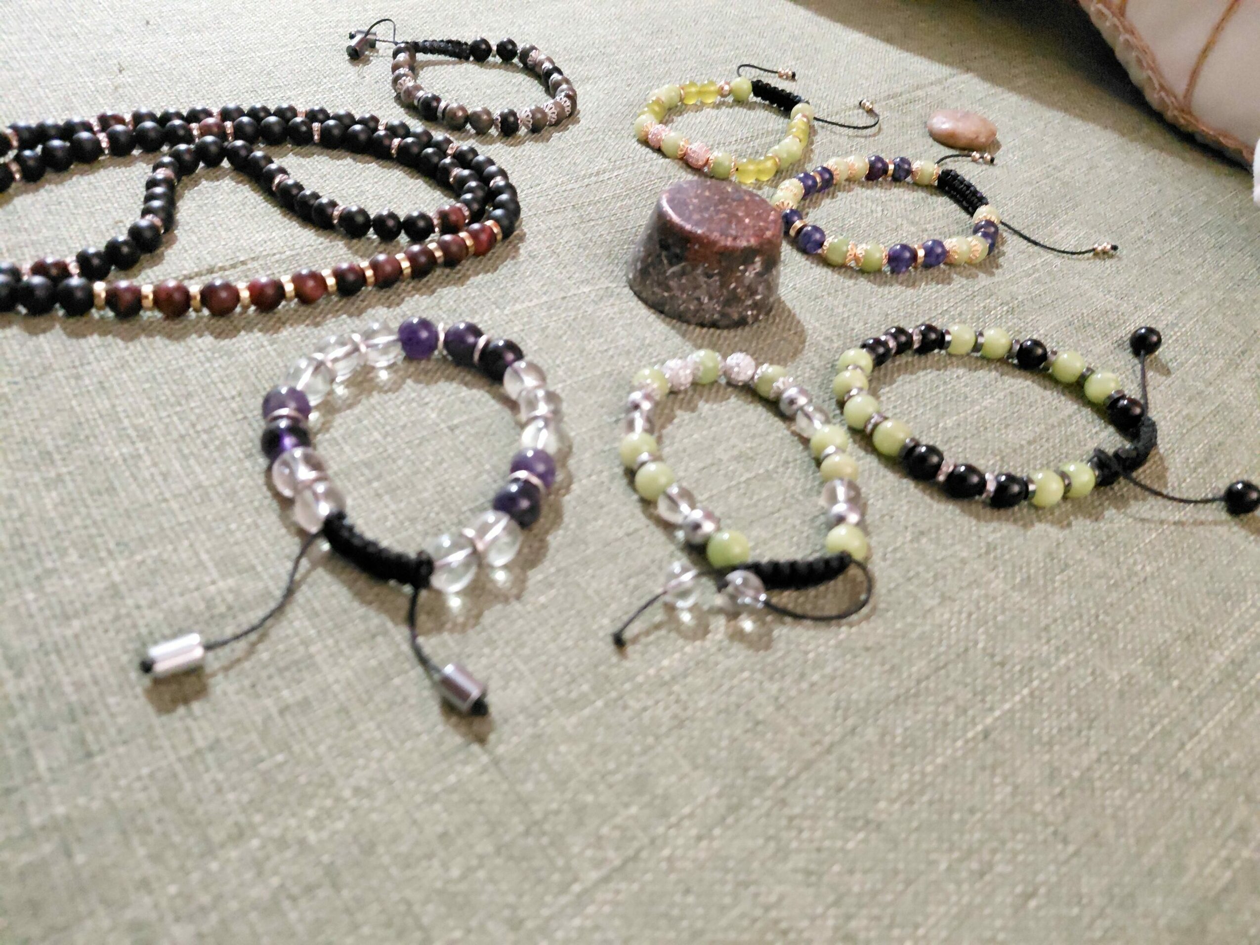 Various beaded bracelets and accessories arranged on a fabric surface, with different colors and patterns.