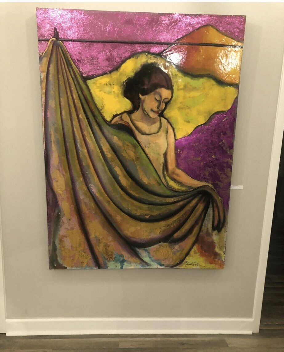 Colorful painting of a woman holding a large fabric, with a landscape background, mounted on a white wall.