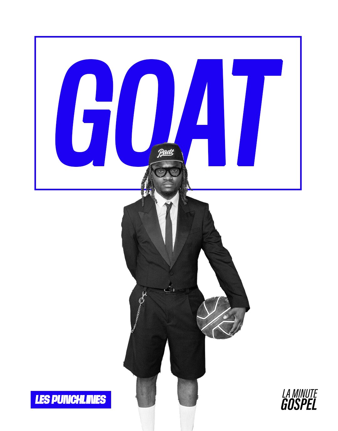 Person in a suit holding a ball, standing in front of a sign that says GOAT in blue letters, with a logo and text.