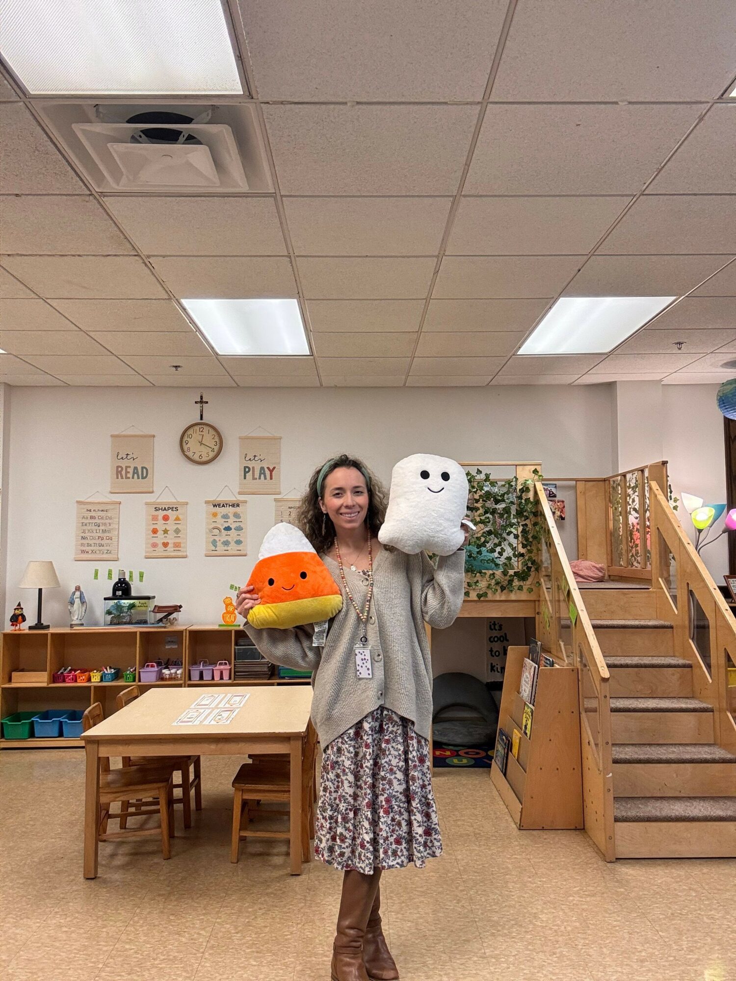 Person holding a plush toy in a room with wooden furniture and wall decorations.