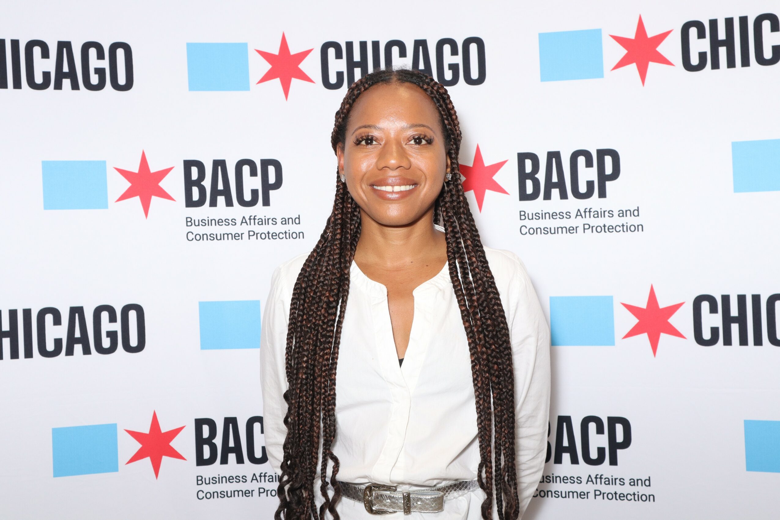 Smiling woman with long braided hair in front of a backdrop with Chicago and BACP logos.