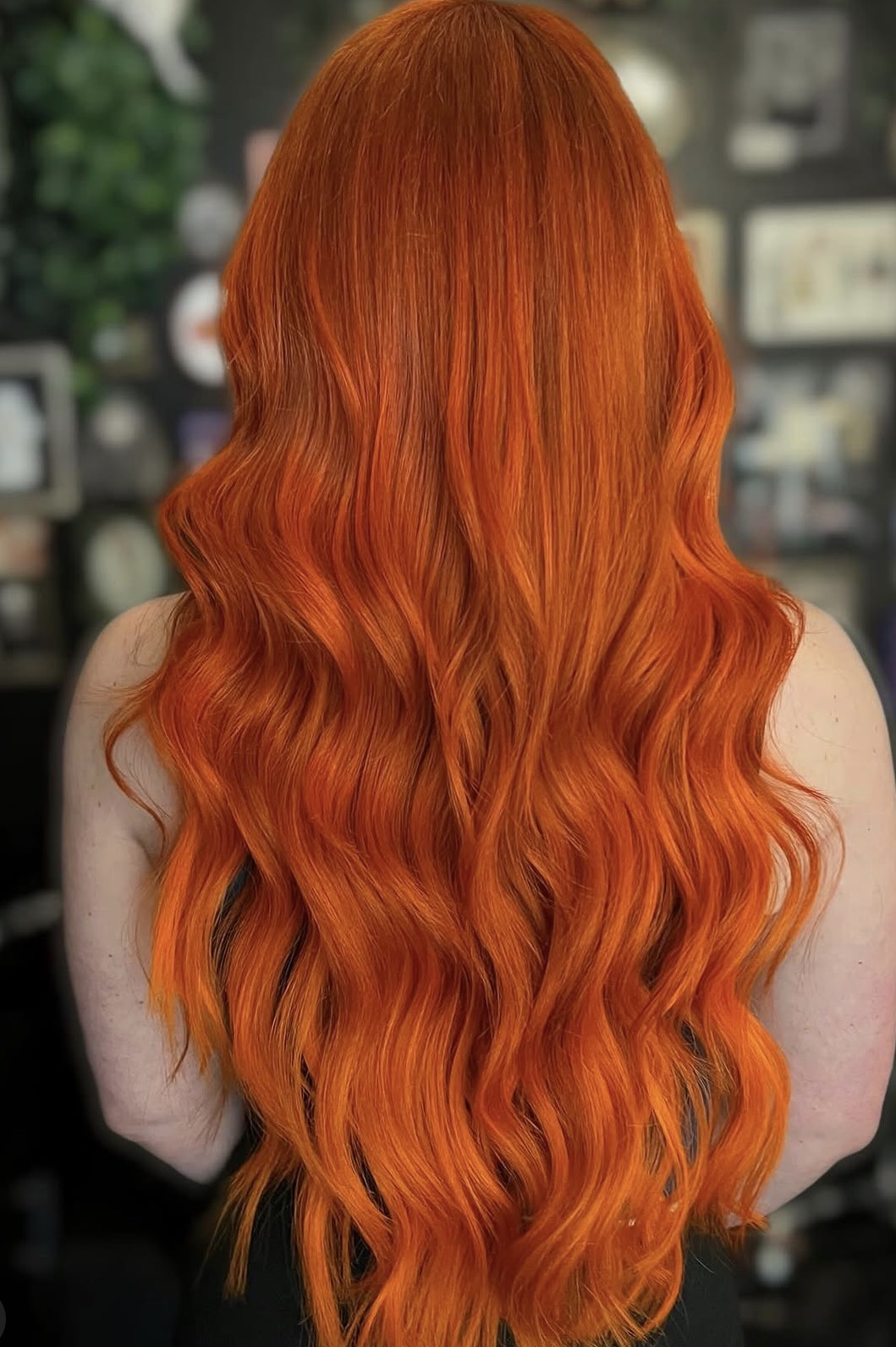 Back view of a person with long, wavy, bright orange hair.