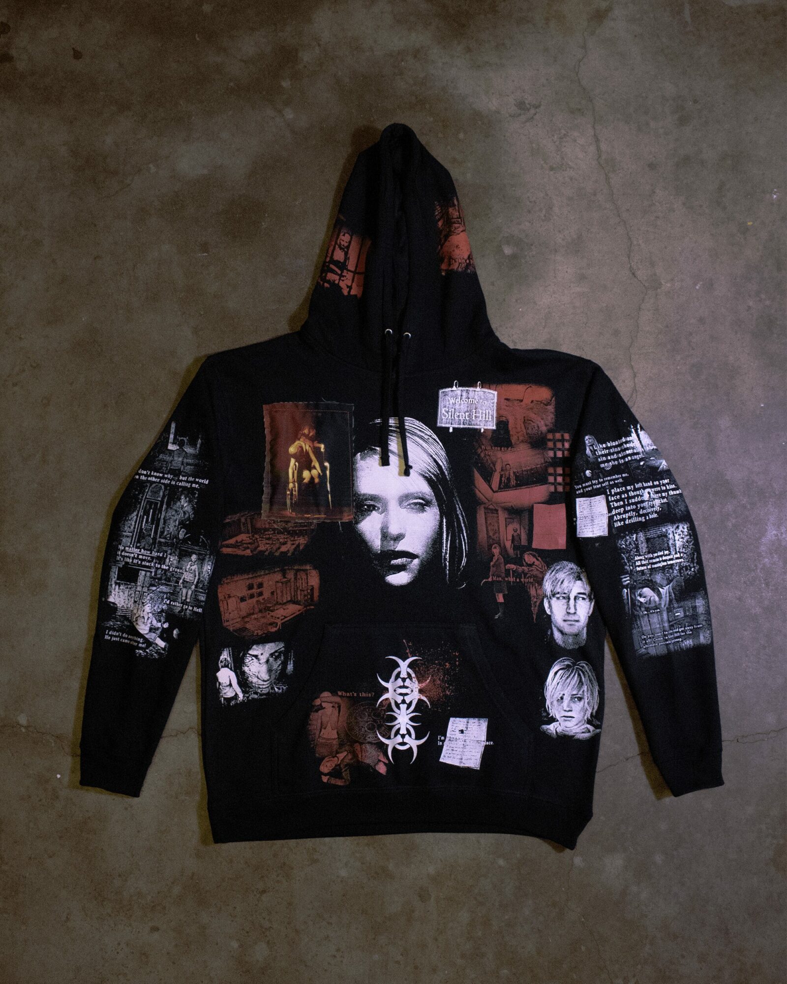 Black hoodie with images of a woman's face, text, and various graphics in red, white, and gray colors.