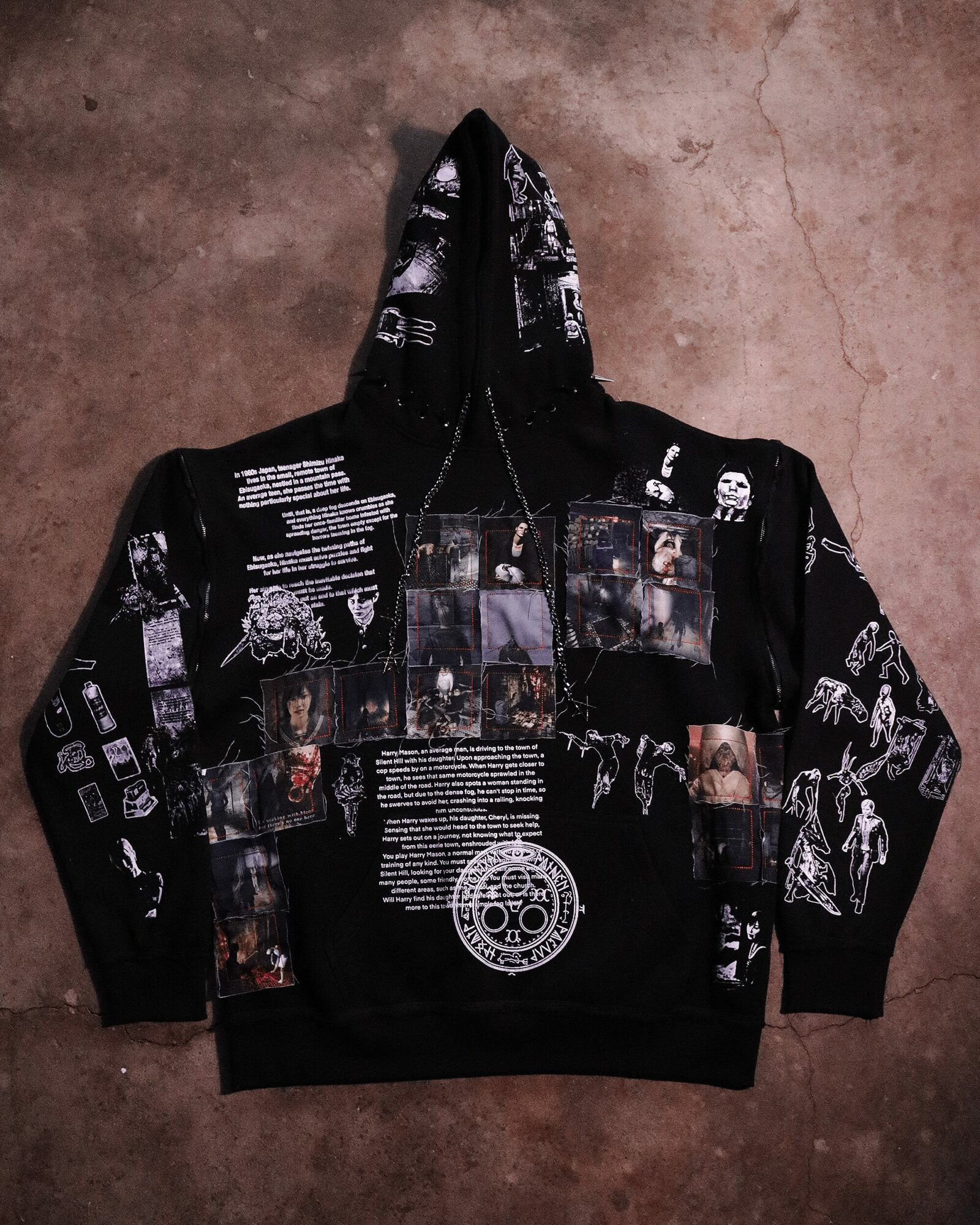 Black hoodie with white text and images, featuring a collage of photos and graphics, laid flat on a surface.