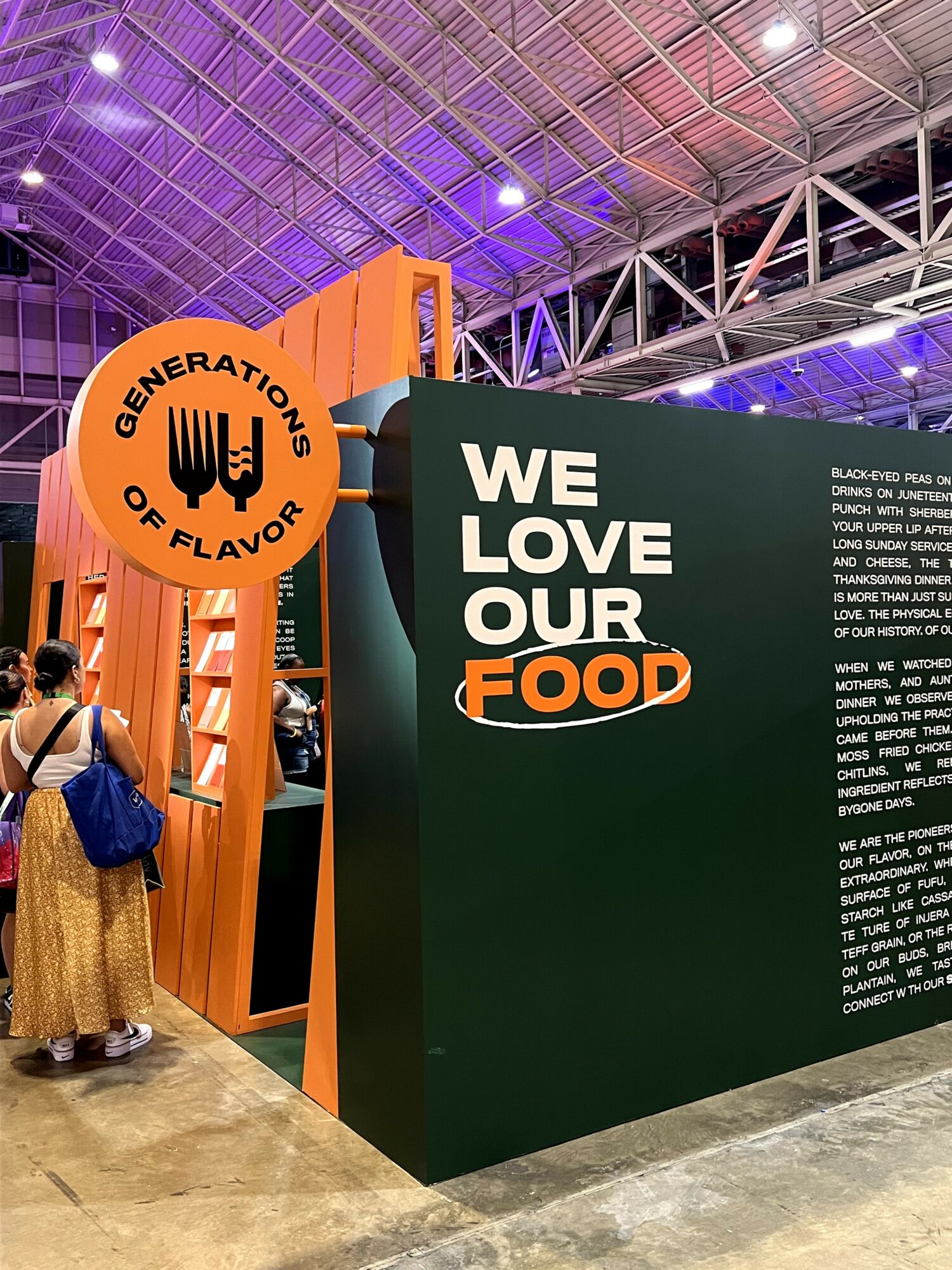 People at an exhibition booth with a sign reading 