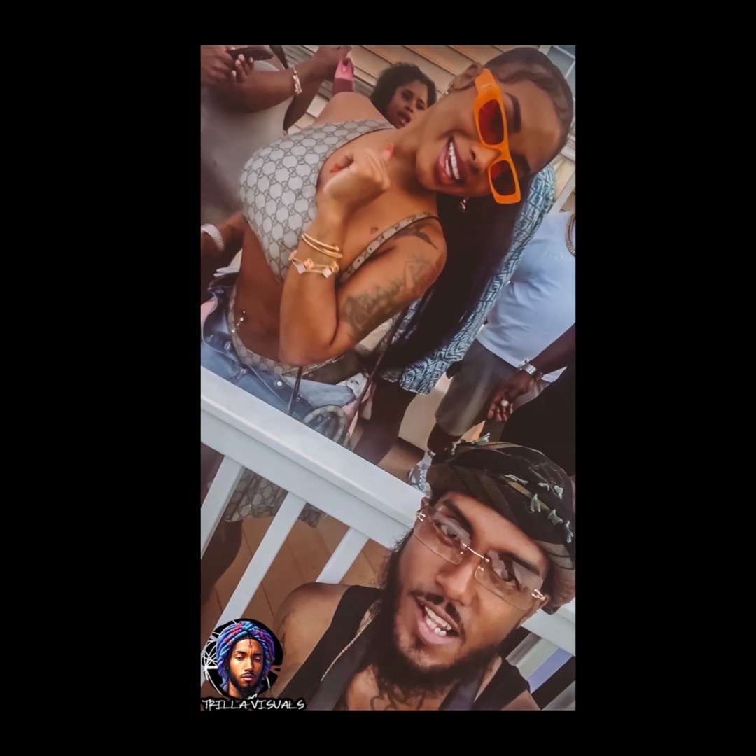 Two people smiling, woman with sunglasses and tattoos, man with glasses and bandana, in a social setting.