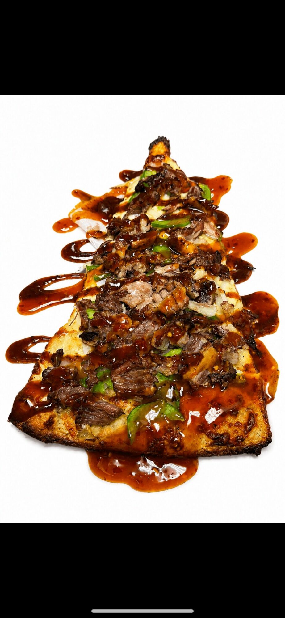 A pizza topped with various meats, vegetables, and drizzled with sauce, arranged in a triangular shape on a white background.