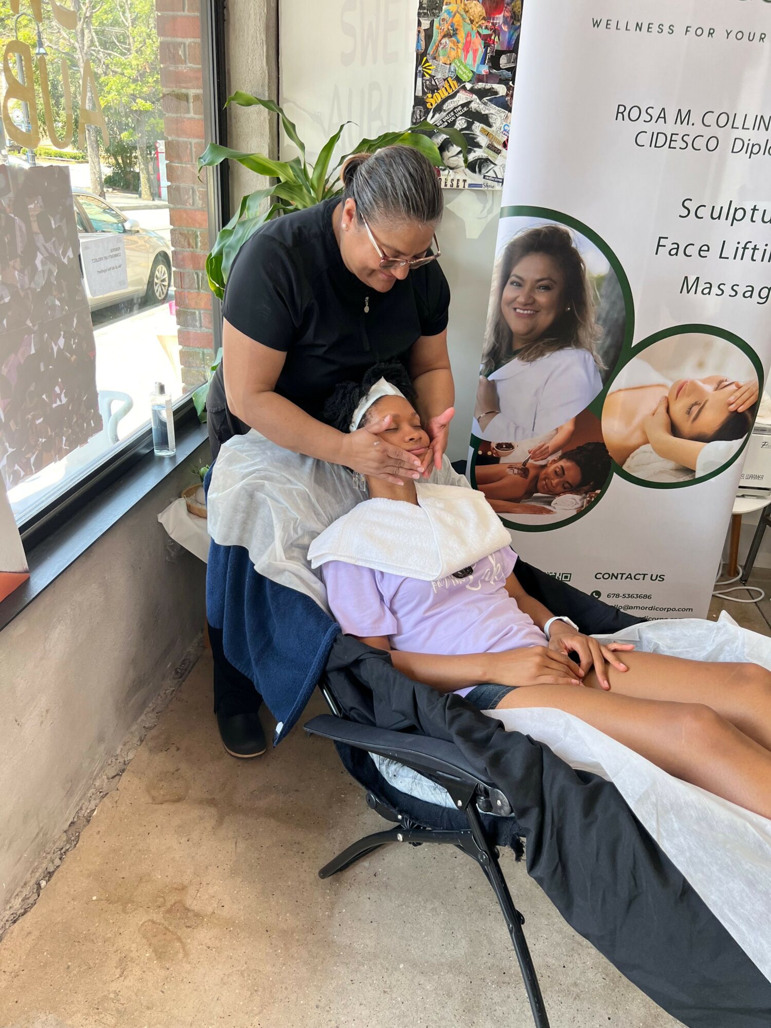 Person receiving facial treatment at a spa, lying on a treatment bed with a practitioner applying a mask, in a wellness center.
