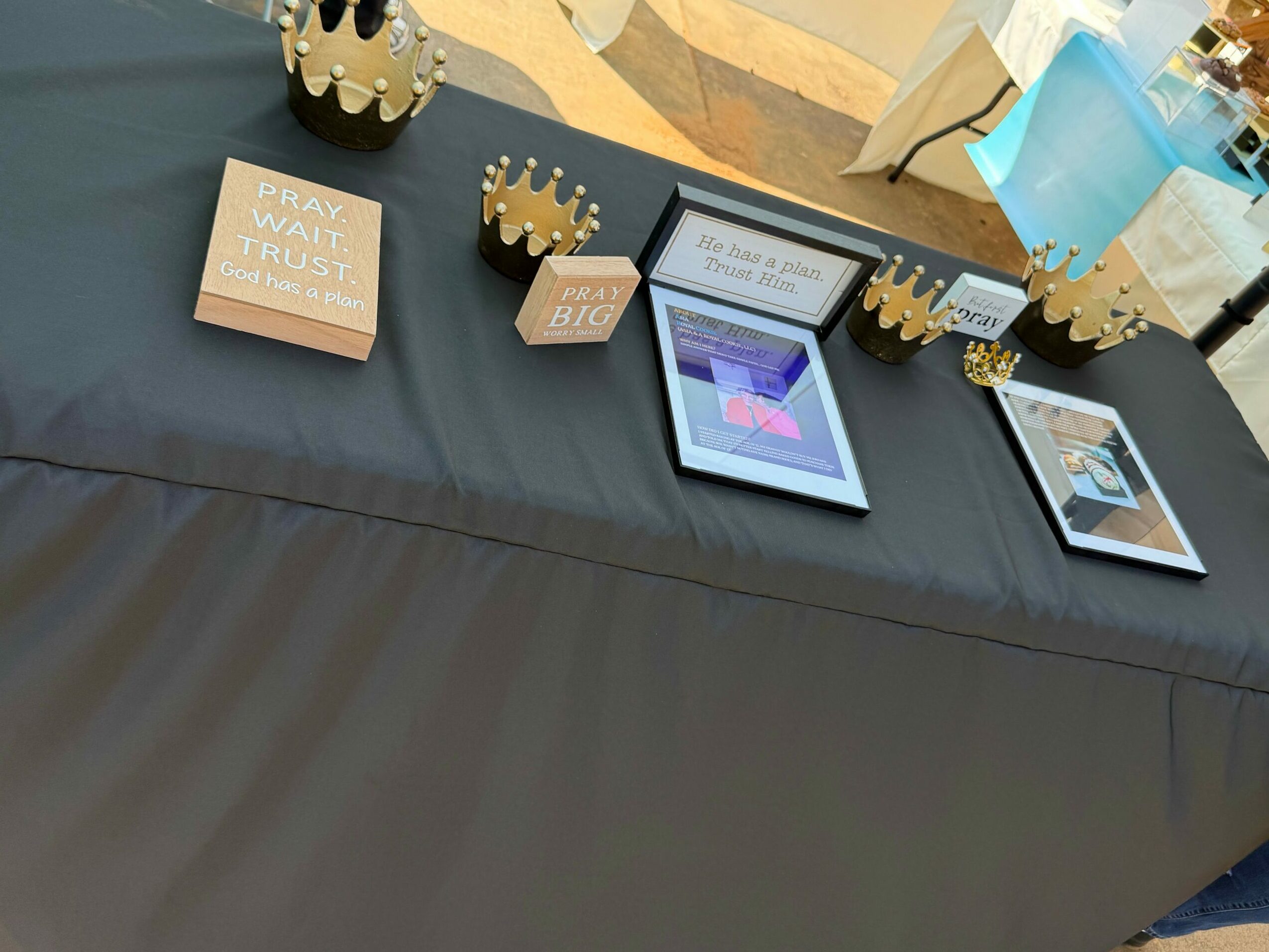 Three framed pictures and a pink box on a dark surface, with decorative gold-colored objects nearby.