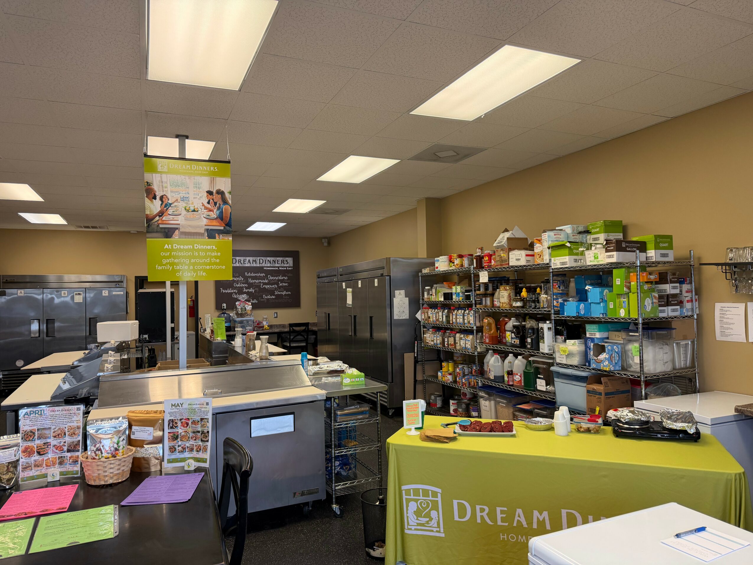 Interior of a store with shelves stocked with products, a checkout counter, and a yellow sign reading 'Dream D' in front.