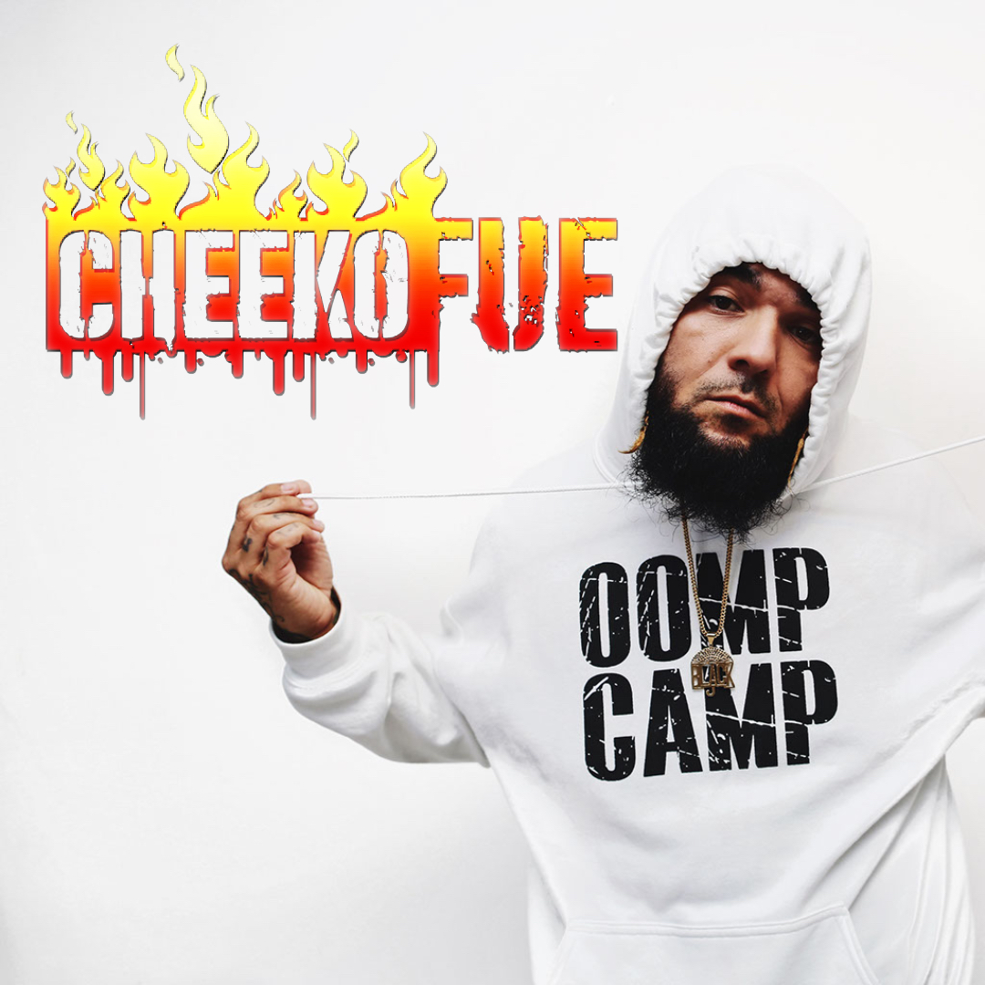 Man with a beard wearing a white hoodie holding a string with a logo that says 'CHEEKFUE' with flames, and a hoodie with 'OAMP CAMP' text.