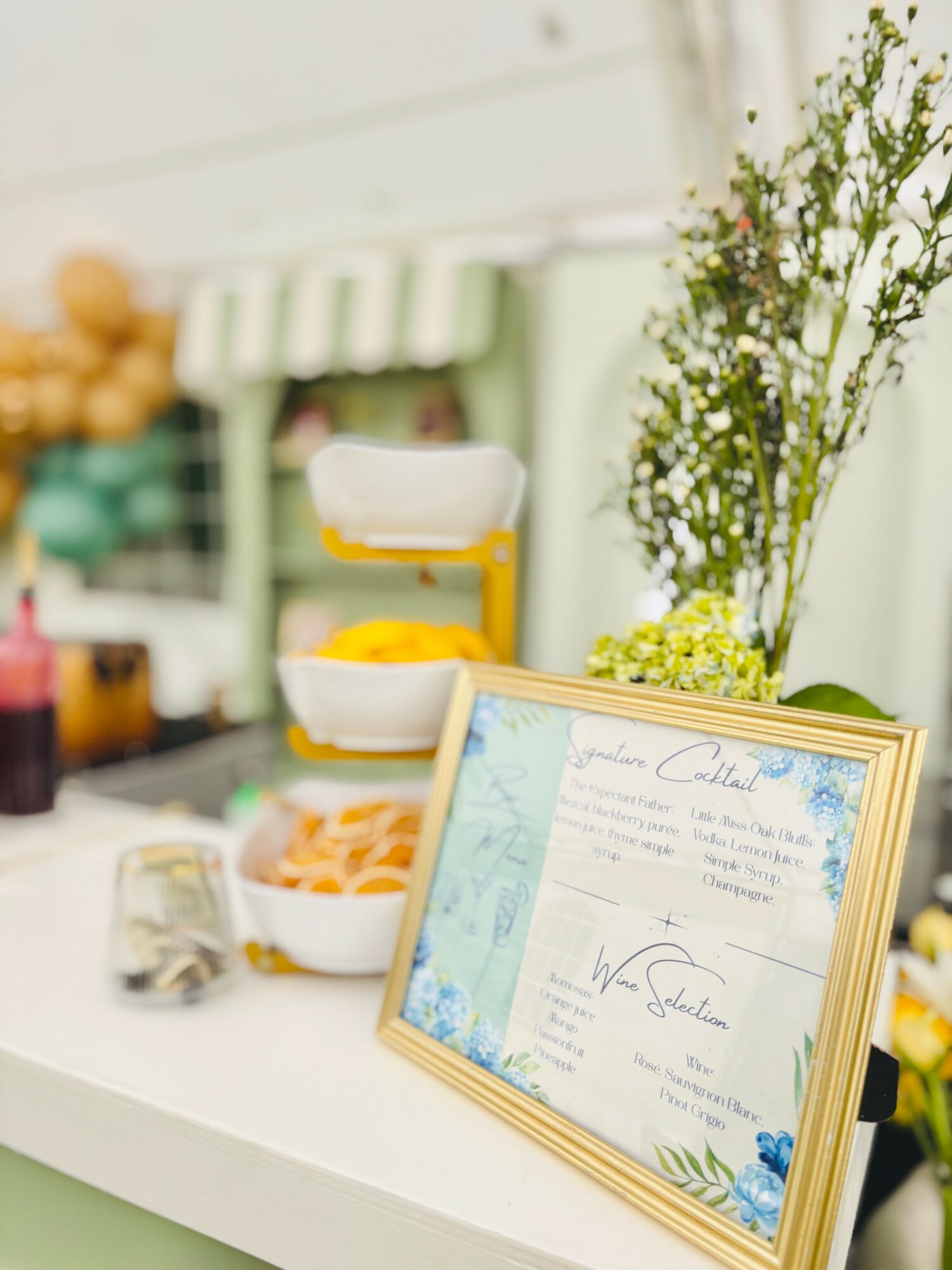 Framed certificate on a white table with flowers and a food stand in the background.