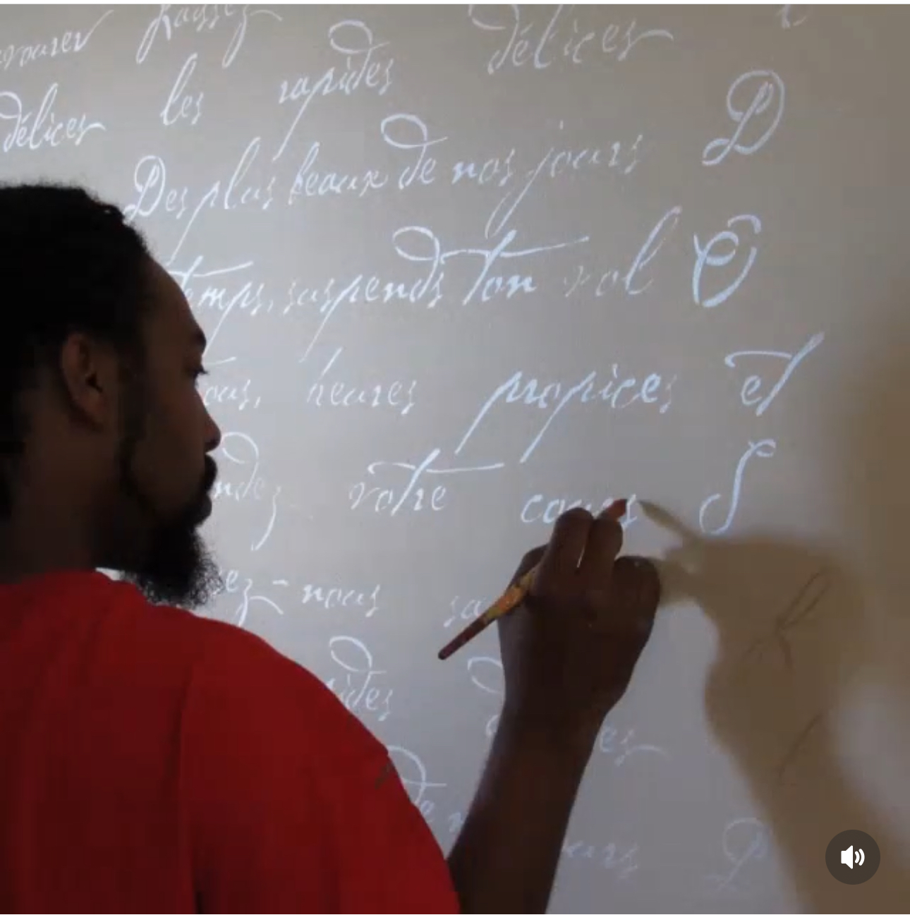 Person writing on a whiteboard with cursive text, holding a marker, facing left, with a shadow cast on the board.