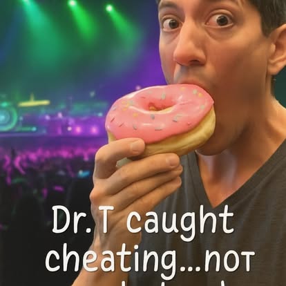 Person holding a pink frosted donut near mouth with colorful stage background, smiling.