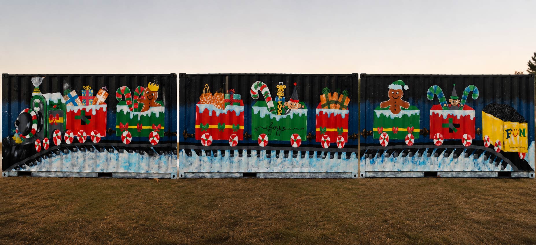 Colorful Christmas-themed mural with decorated train, gingerbread men, and festive elements on a black fence, outdoors on grass.