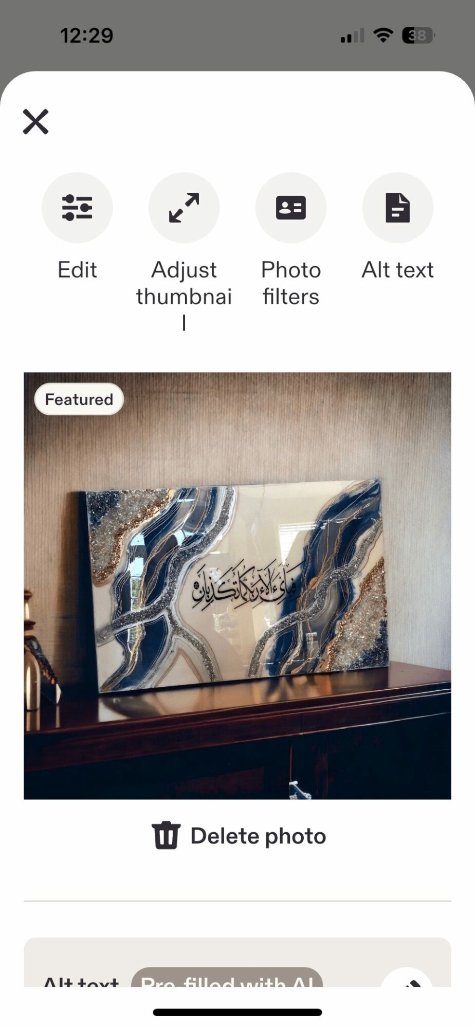 Television screen displaying abstract artwork with blue, white, and beige colors, placed on a wooden surface.